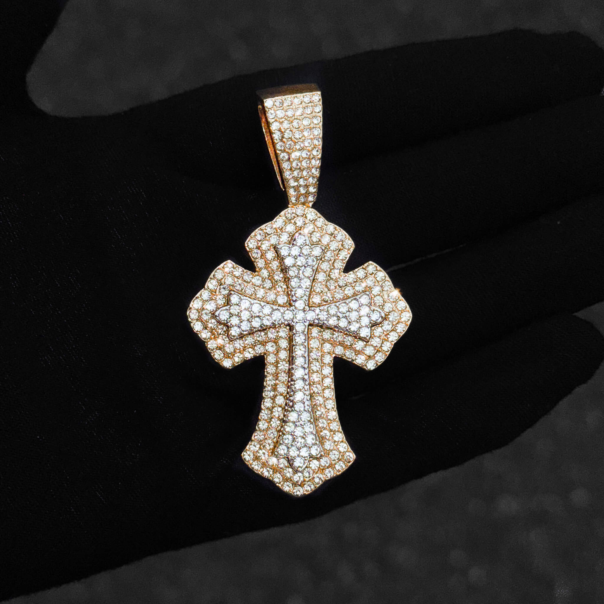 Gold 42mm iced-out men’s cross pendant covered in pavé clear stones and detailed shaping.