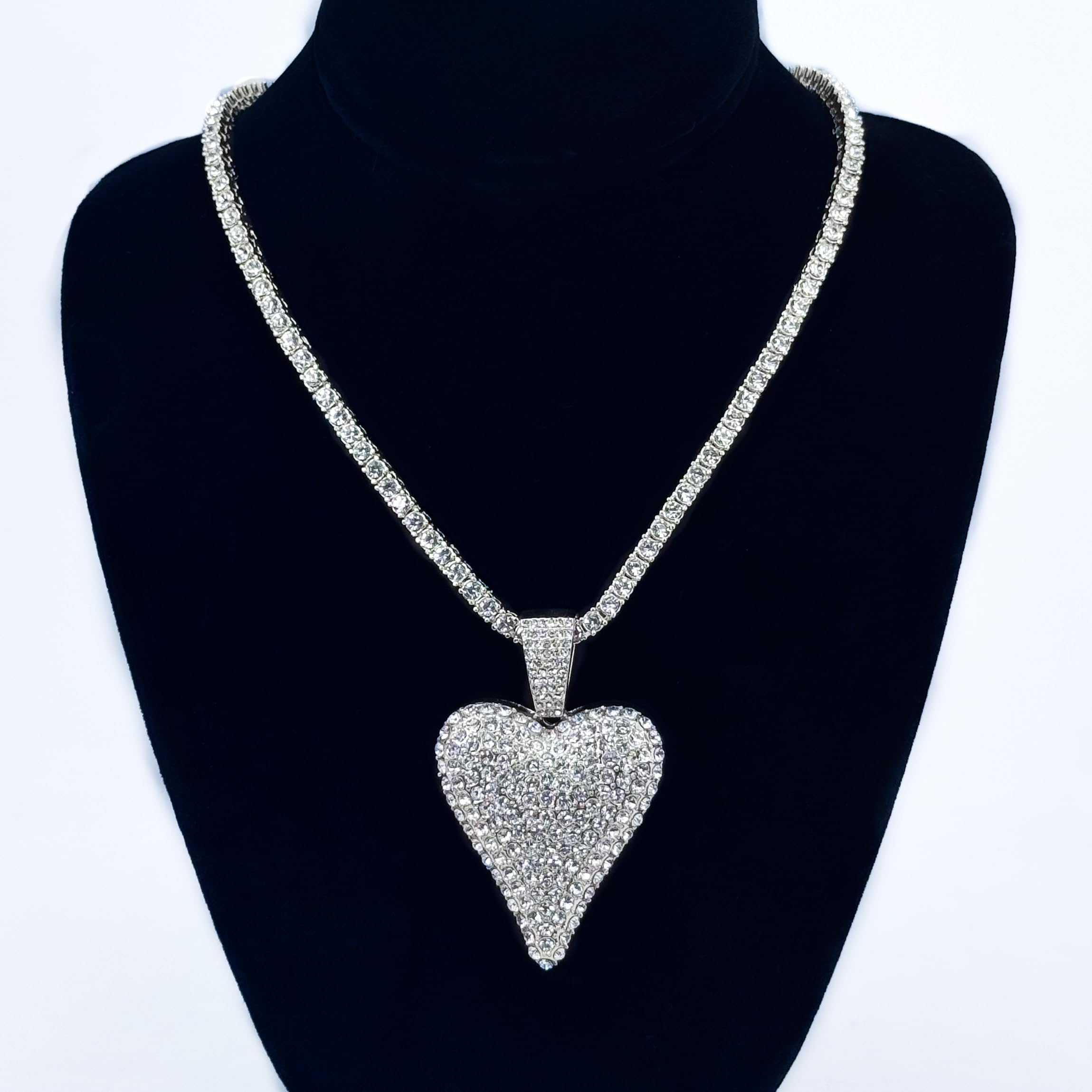Ladies 40mm iced-out silver heart pendant necklace with 4mm tennis chain shown on display stand.