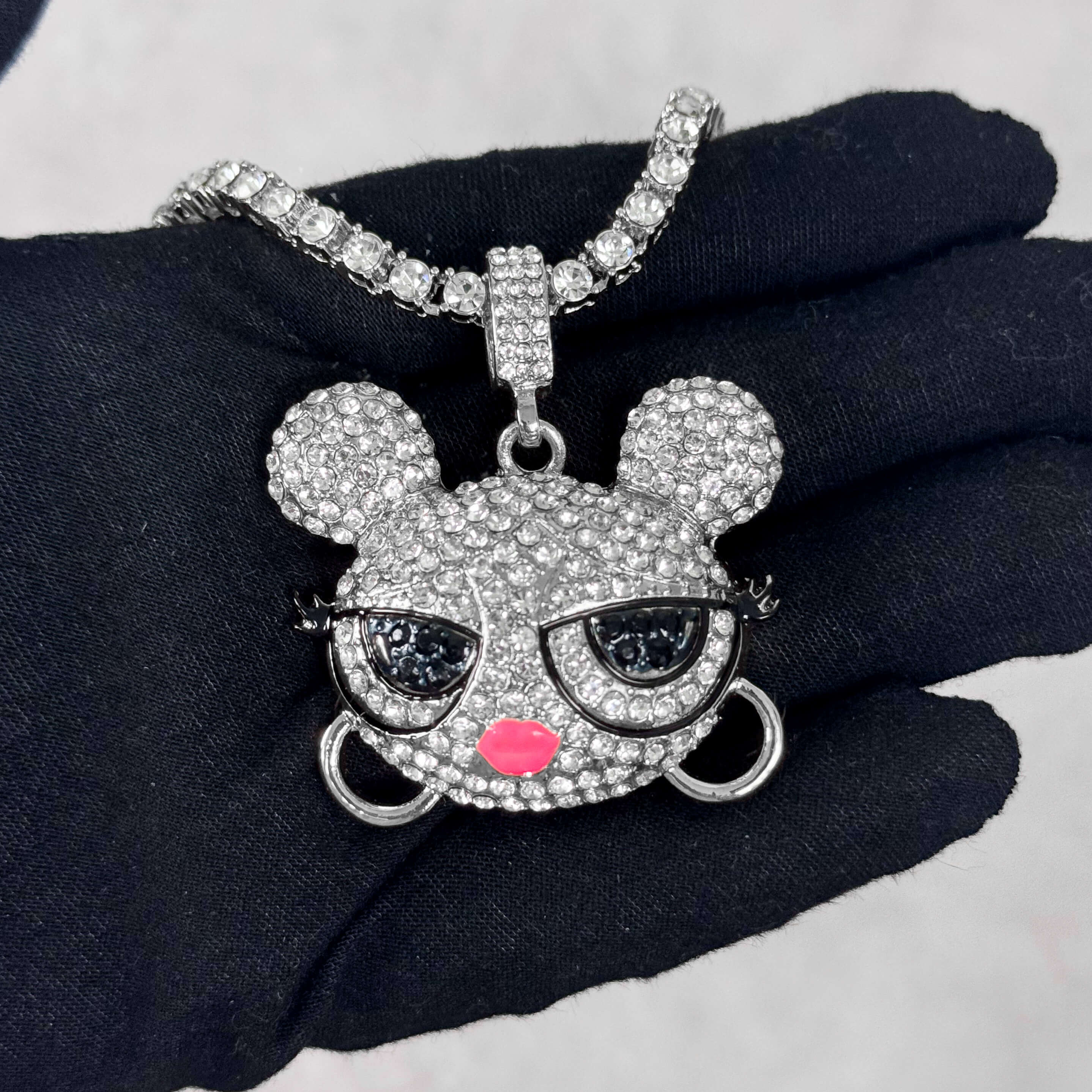 Silver Iced Out Baddie Doll Pendant with Tennis Chain shown in hand, pavé CZ stones.