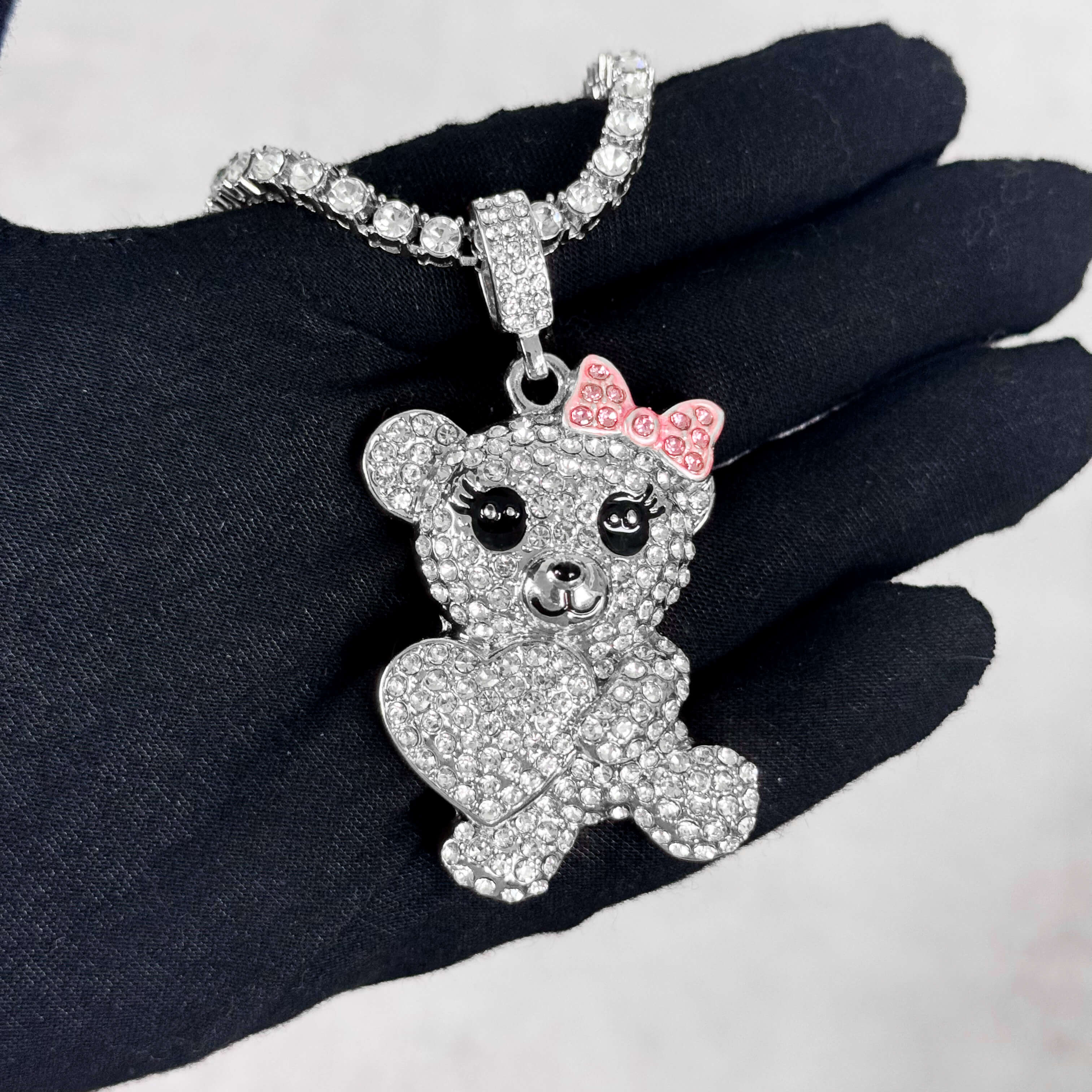 Silver Iced Out Heart Bear Pendant with Tennis Chain shown on hand, sparkling crystal teddy design.