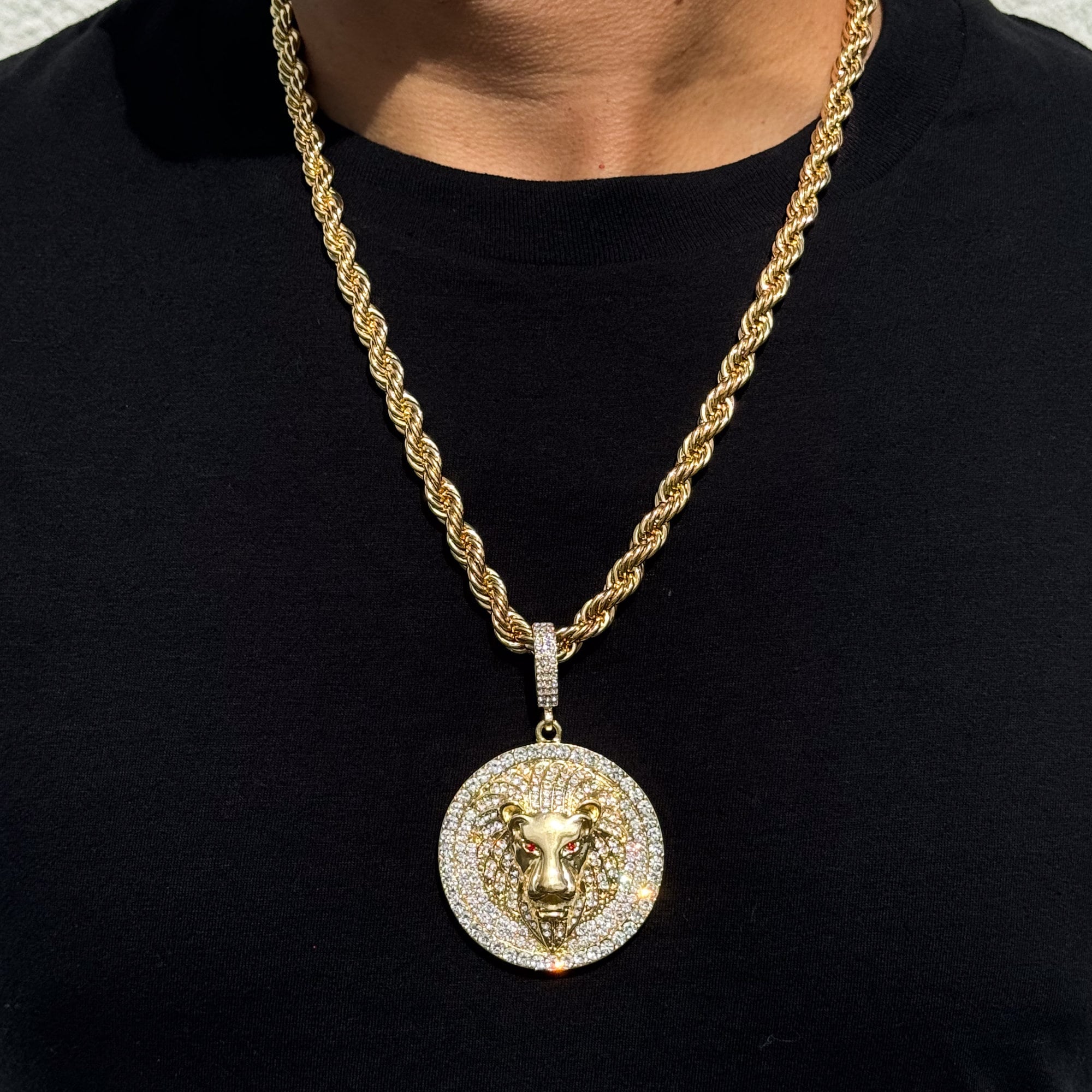 Gold men’s large iced-out lion medallion pendant with red gem eyes on 8mm rope chain necklace.