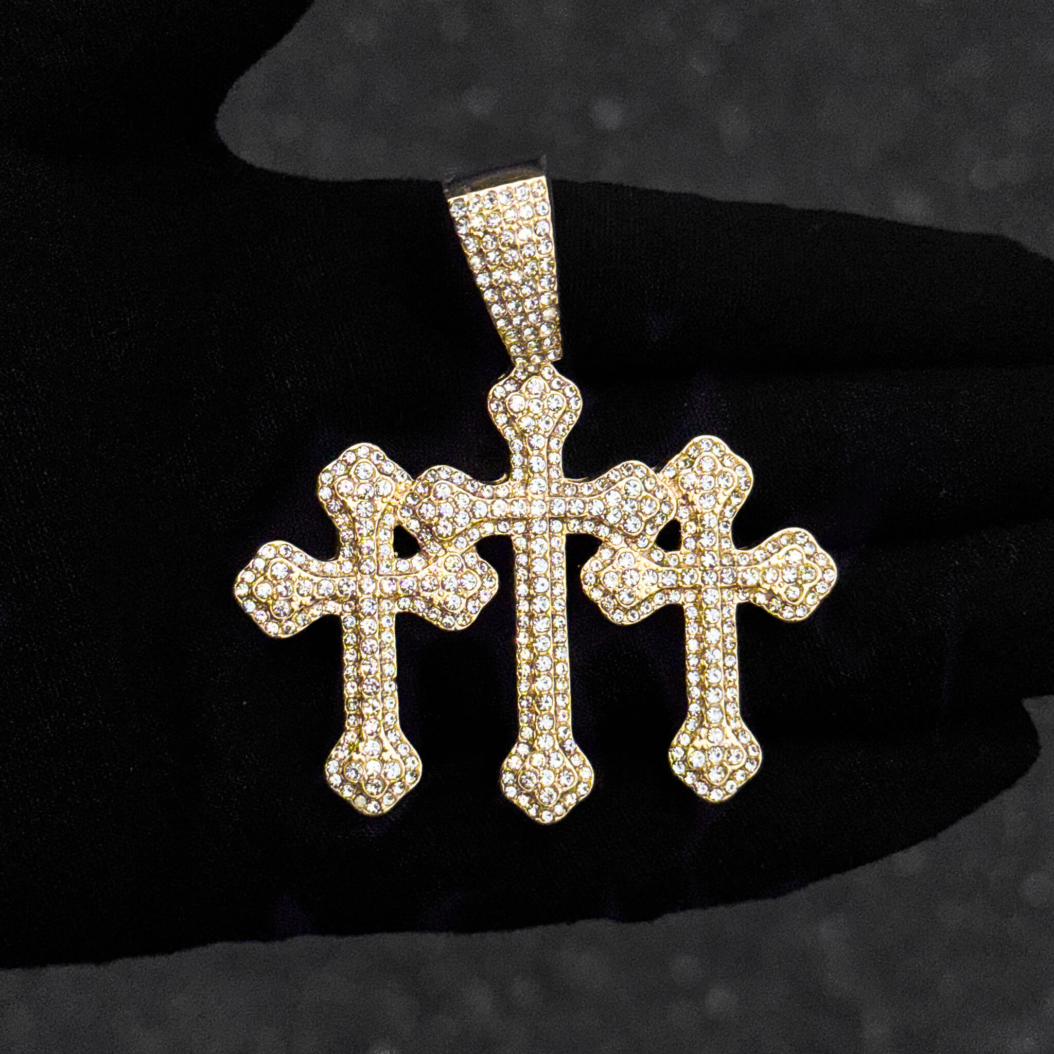 Men’s 60mm gold iced-out triple cross pendant with 8mm rope chain worn over black shirt.