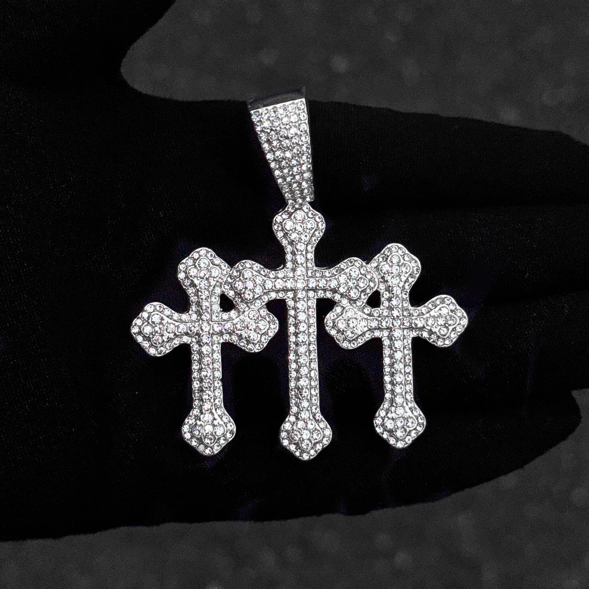 Detailed close-up of silver 60mm iced-out triple cross pendant covered in shimmering stones.