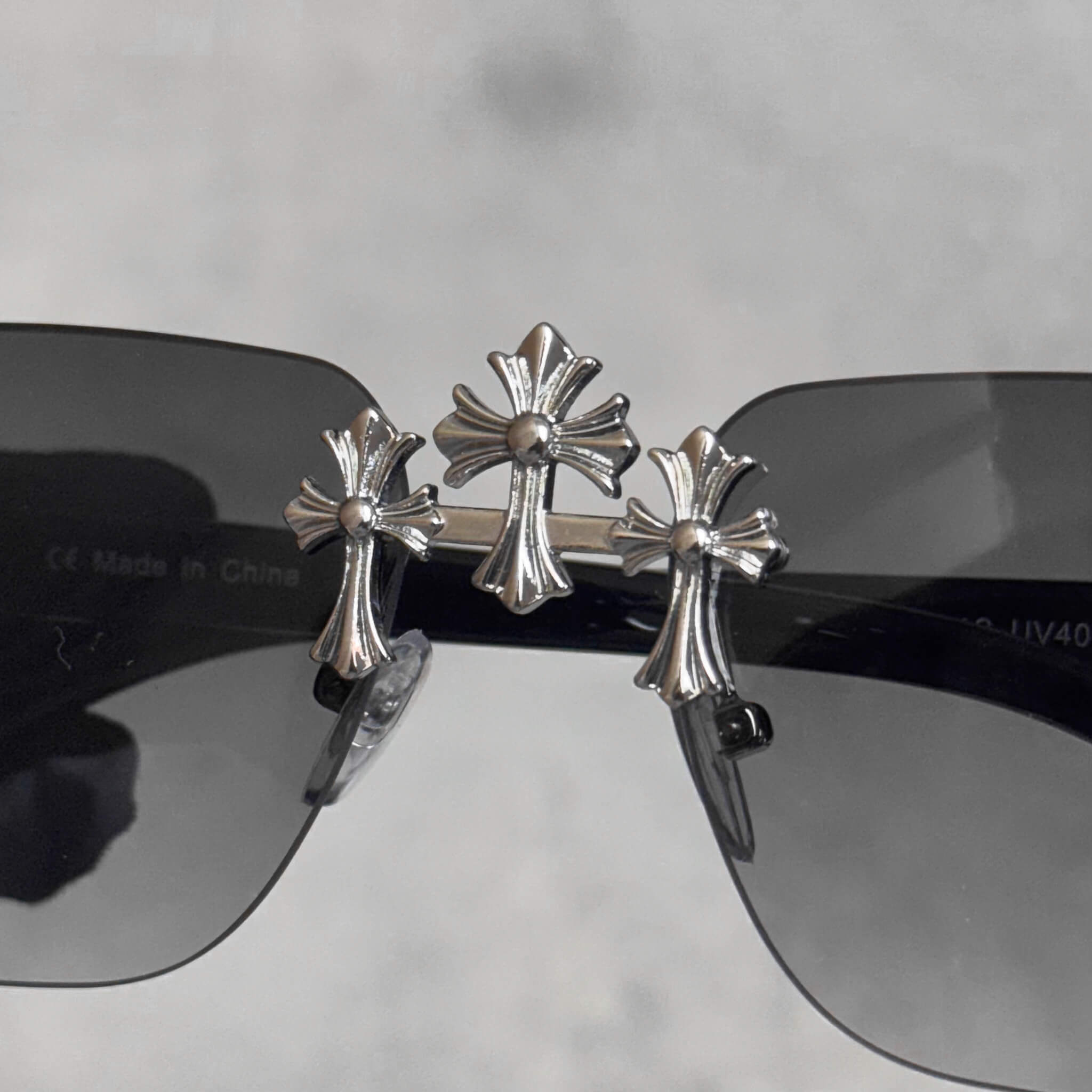 Solid Triple Cross Sunglasses featuring smoke lenses and polished silver cross bridge detailing.