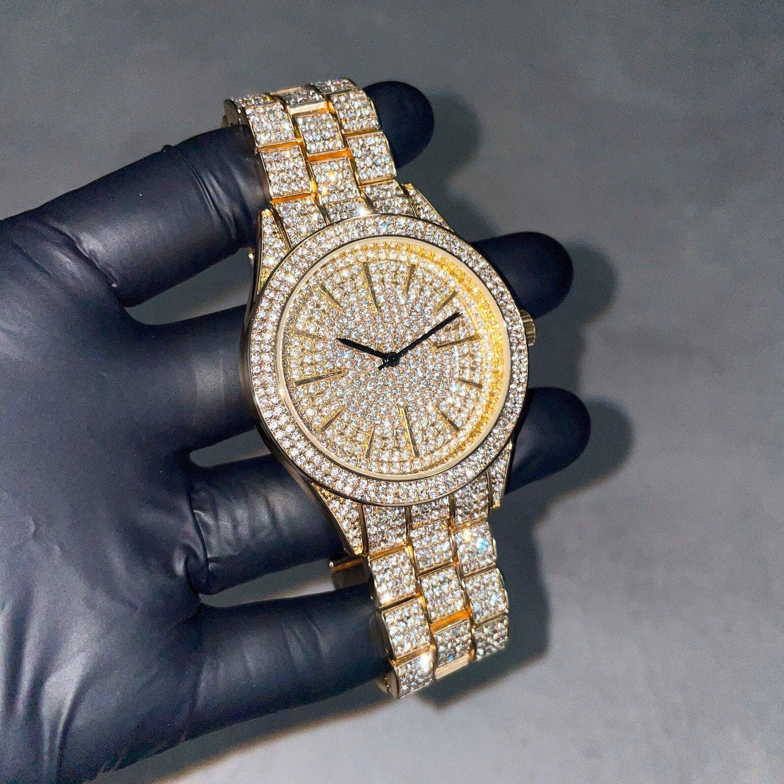 Men's 42mm luxury iced diamond watch shown close up with gold band and brilliant crystal dial.
