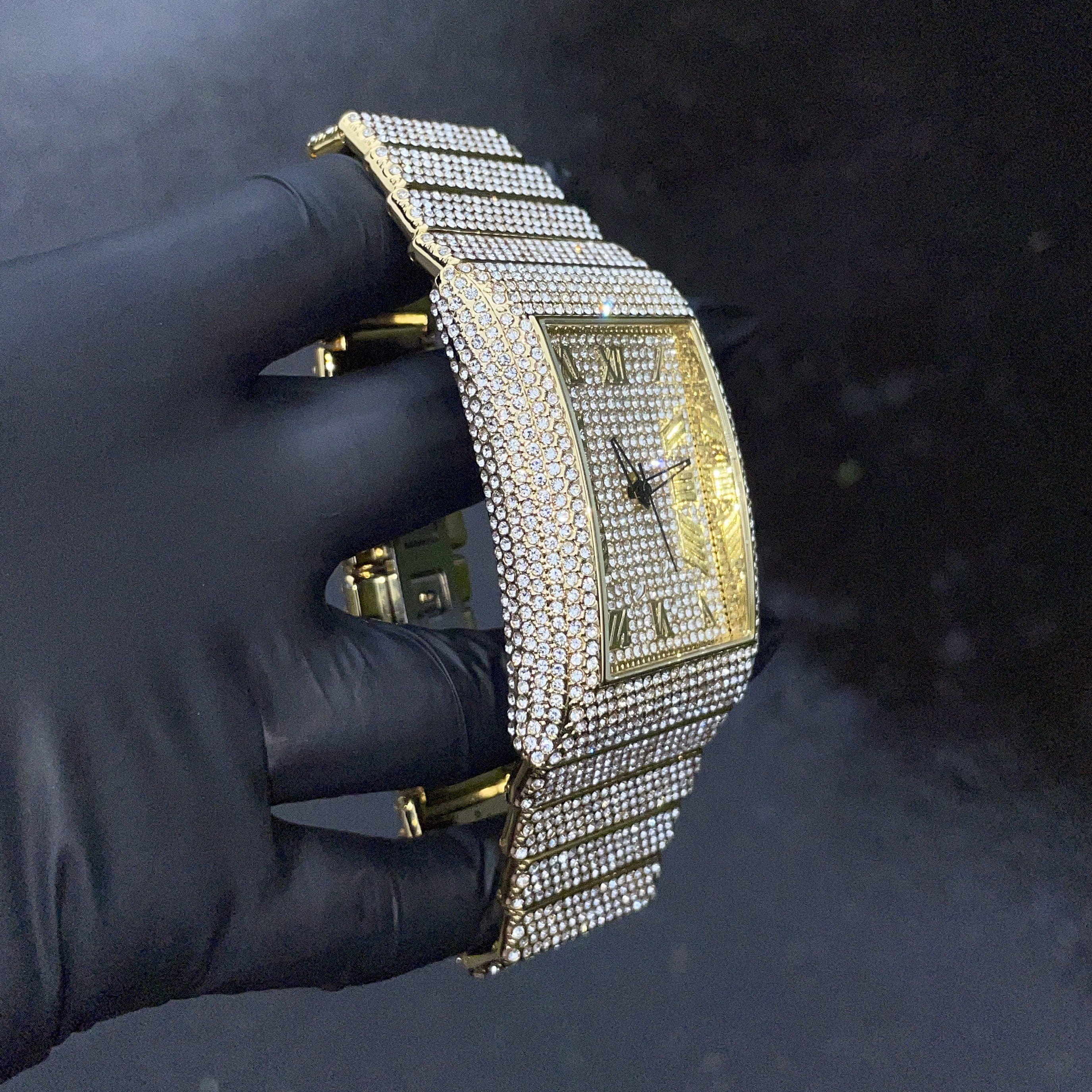 Men's 40mm gold iced out diamond watch shown at an angle with shimmering baguette links.