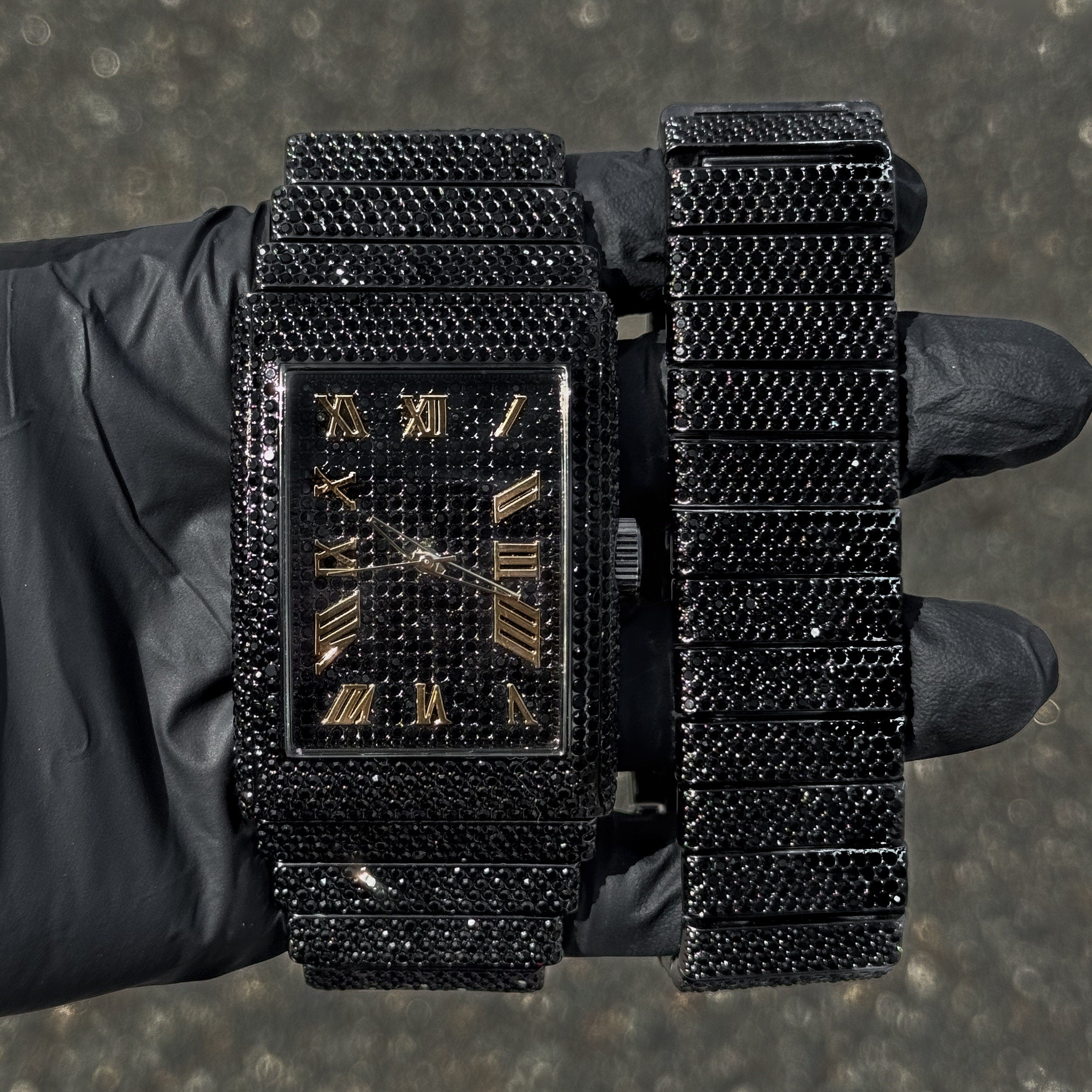 Men's 40mm black fully iced out watch with gold Roman markers and matching bracelet set.