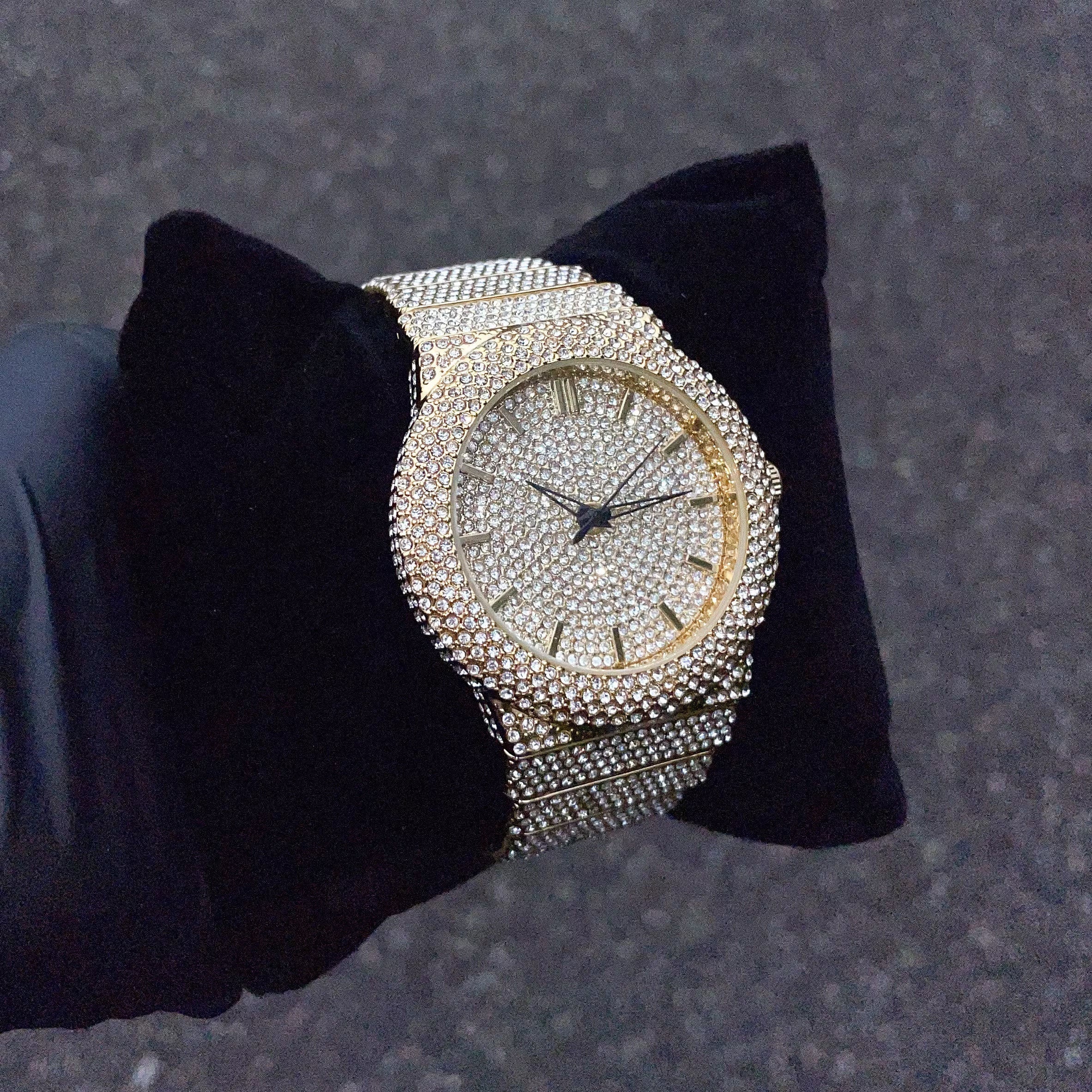 Men's 46mm gold diamond watch displayed on black cushion, fully iced out for premium shine.