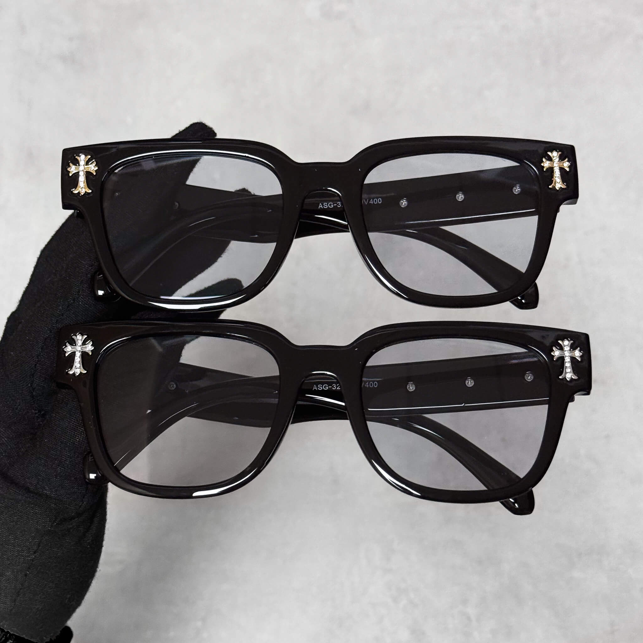 Triple Cross Chrome Inspired Sunglasses with black frame and smoke lenses, gold and silver cross accents on corners.