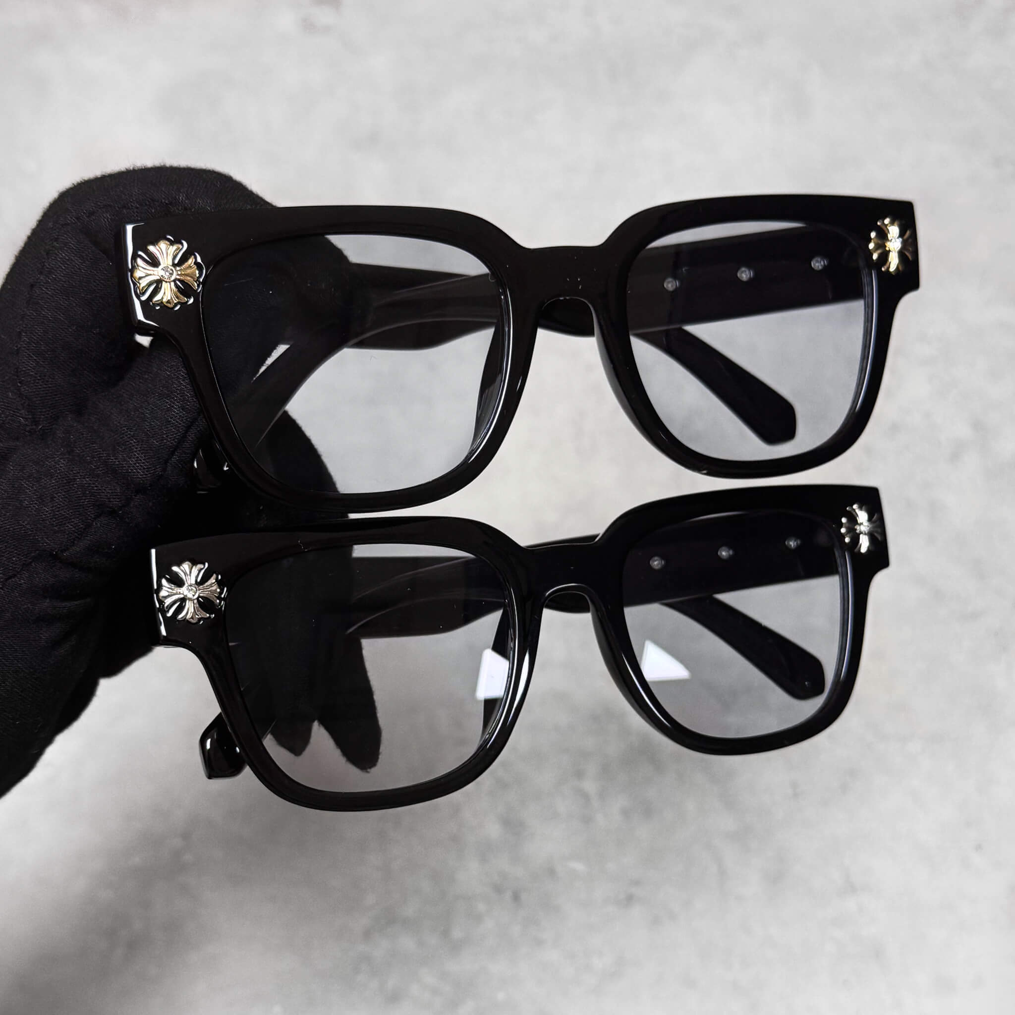 Two pairs of Cross Chrome Inspired Sunglasses with smoke lenses and gold and silver cross corner accents.