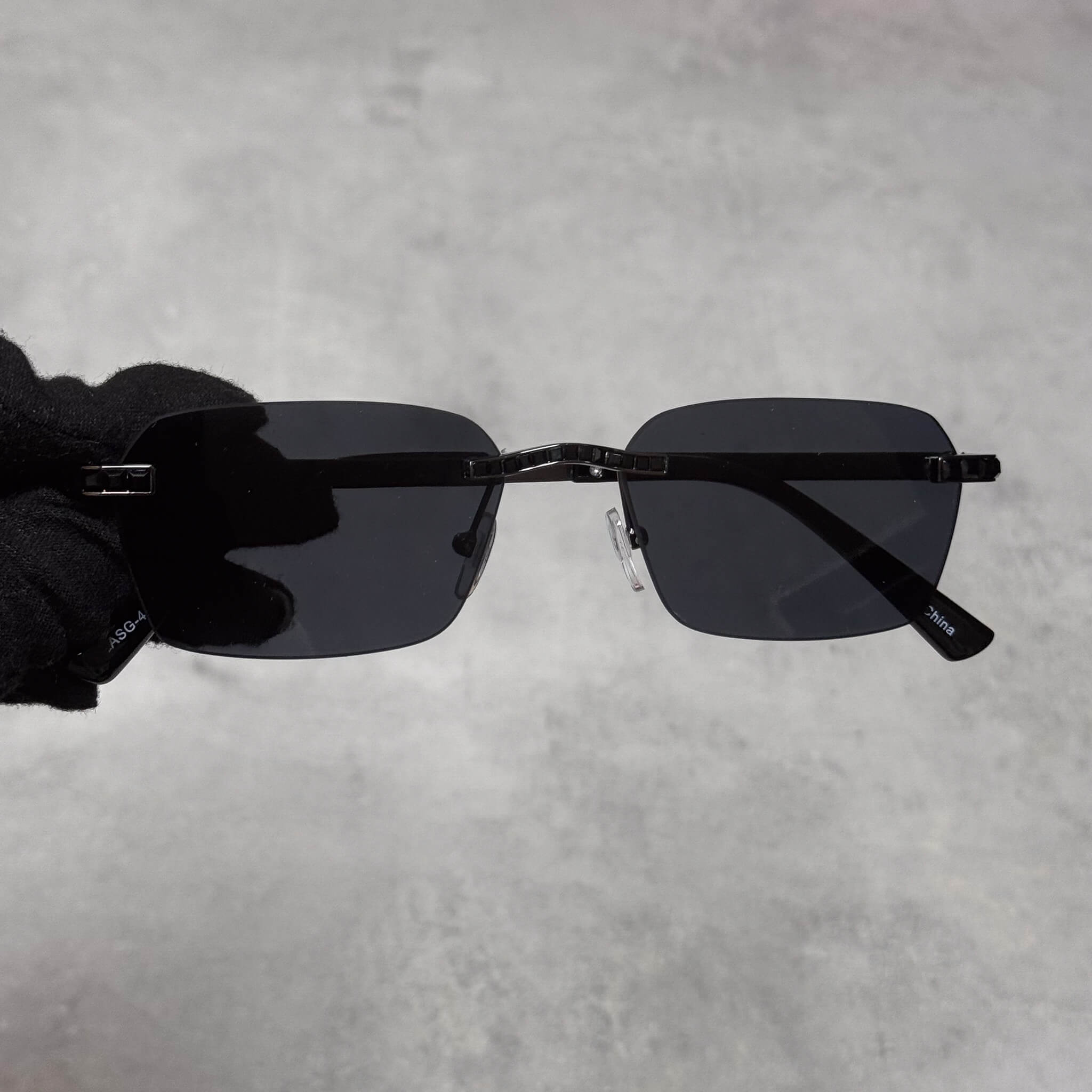 Black lens baguette stone sunglasses with square rimless design and glossy black temples.