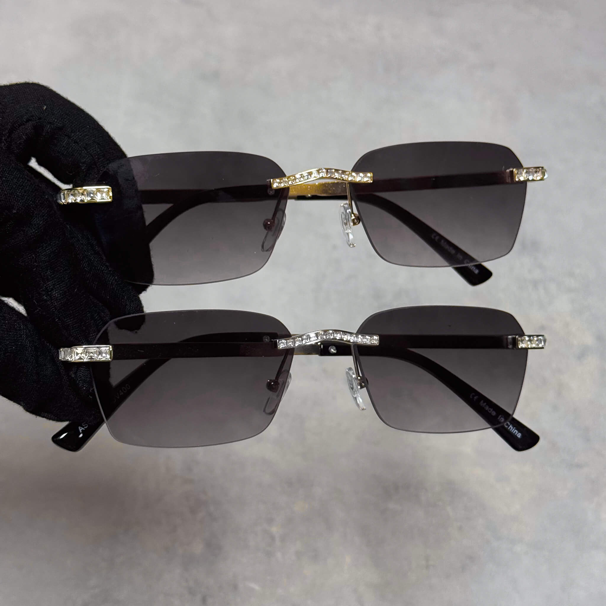 Two pairs of Baguette Stone Sunglasses with smoke lenses and crystal-lined gold and silver frames.