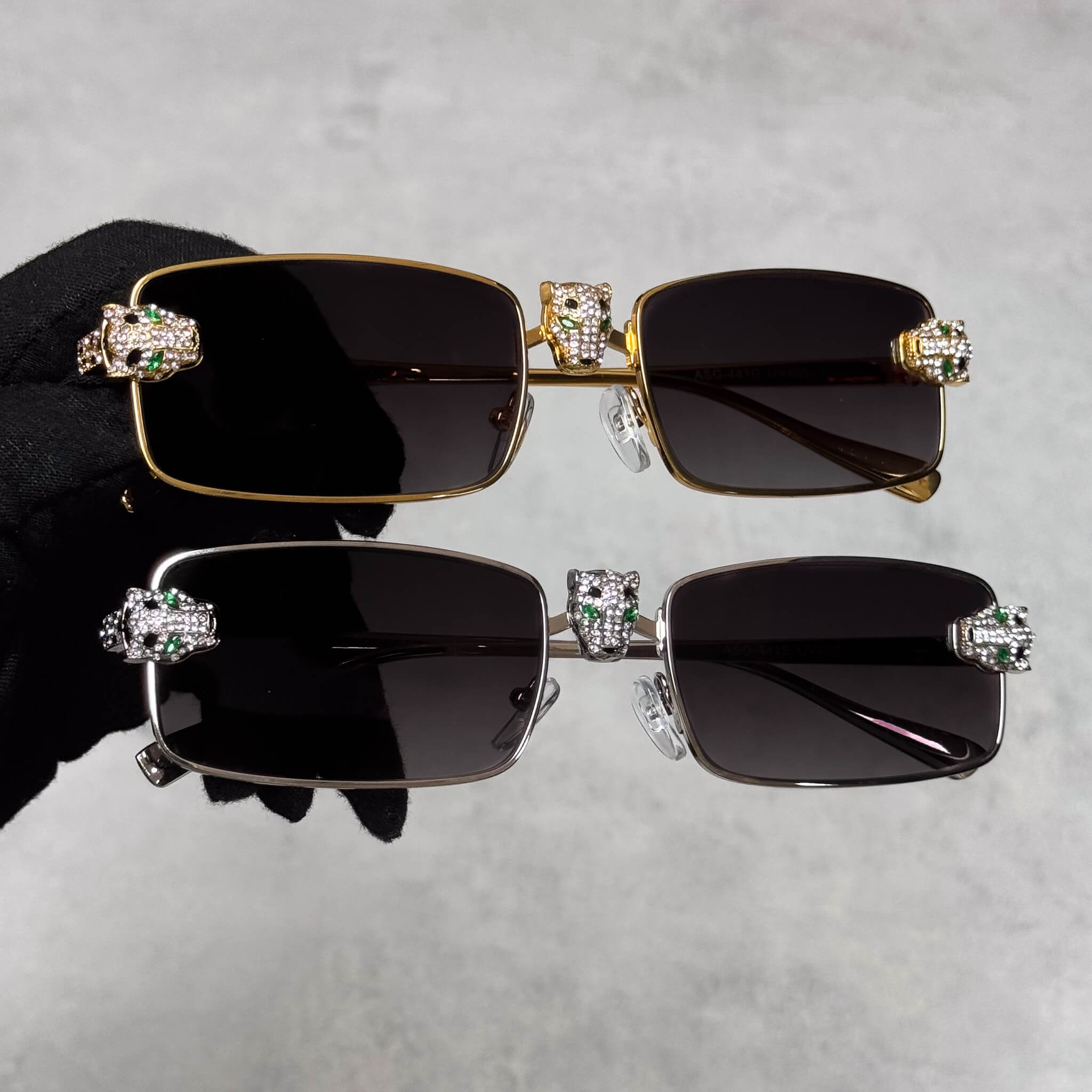 Gold and silver Iced Out Panther Sunglasses with black rectangular lenses and jeweled panther accents.