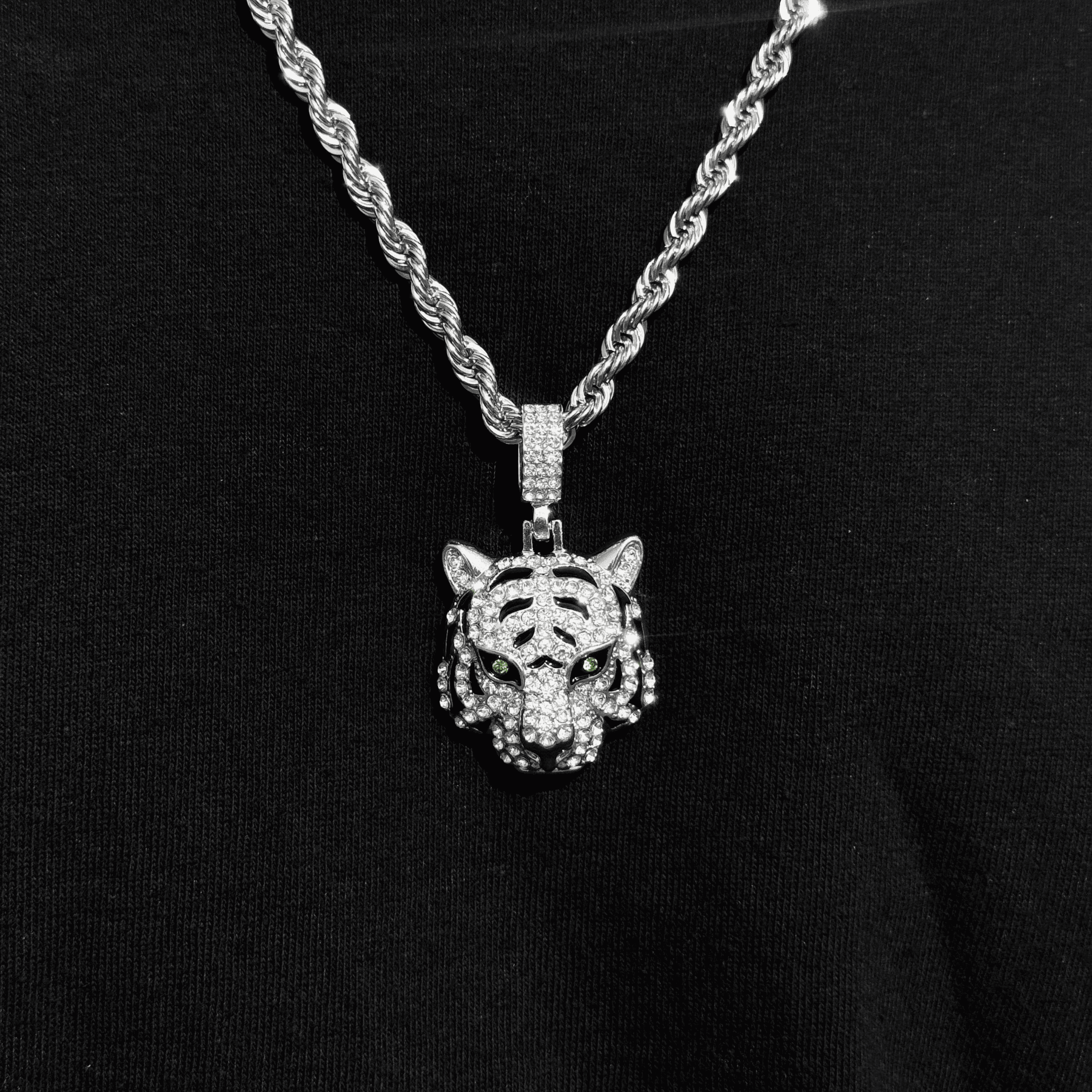 Silver iced out tiger pendant with green crystal eyes on 4mm rope necklace for men.