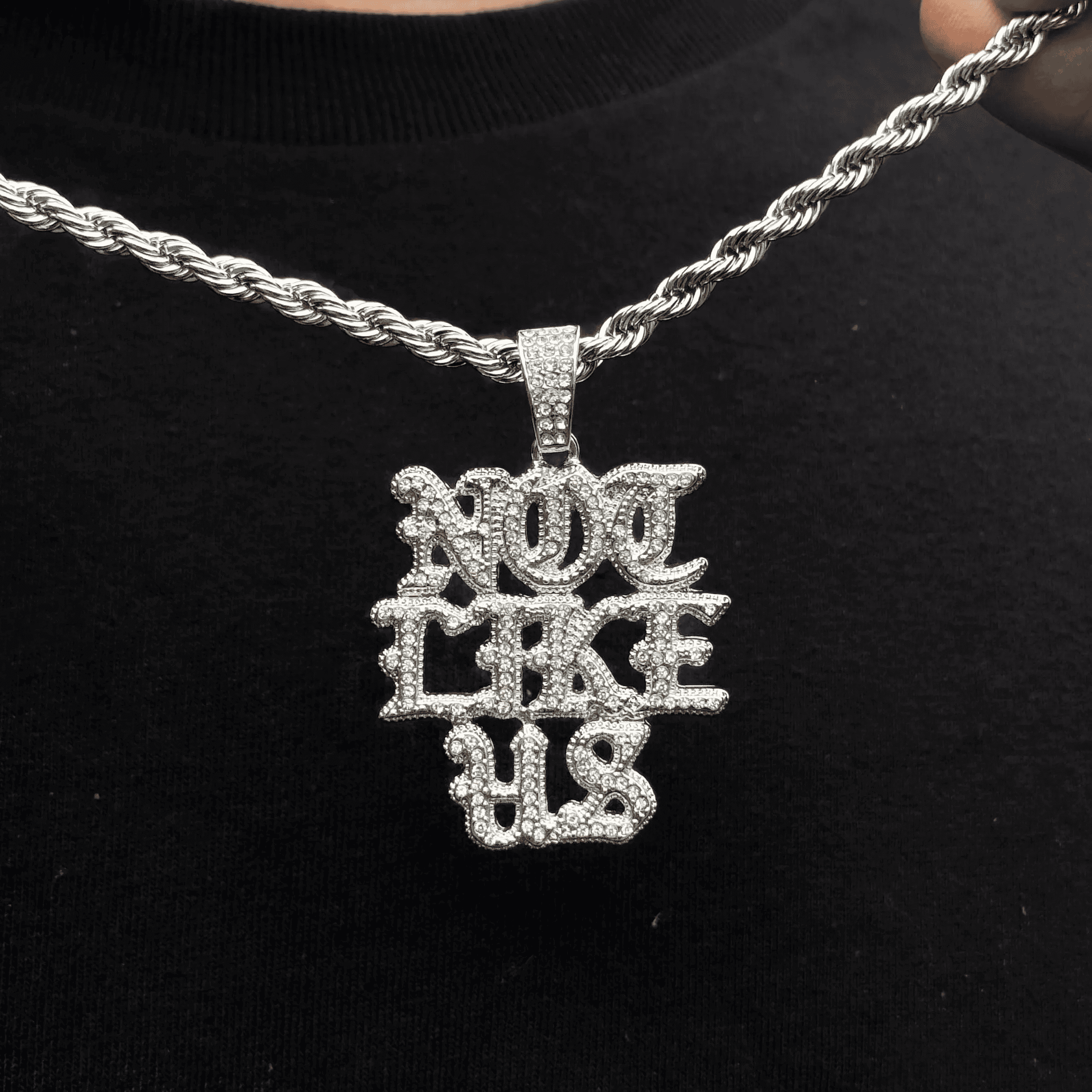 Silver Men's Not Like US iced out pendant with sparkling stones on 4mm rope necklace.