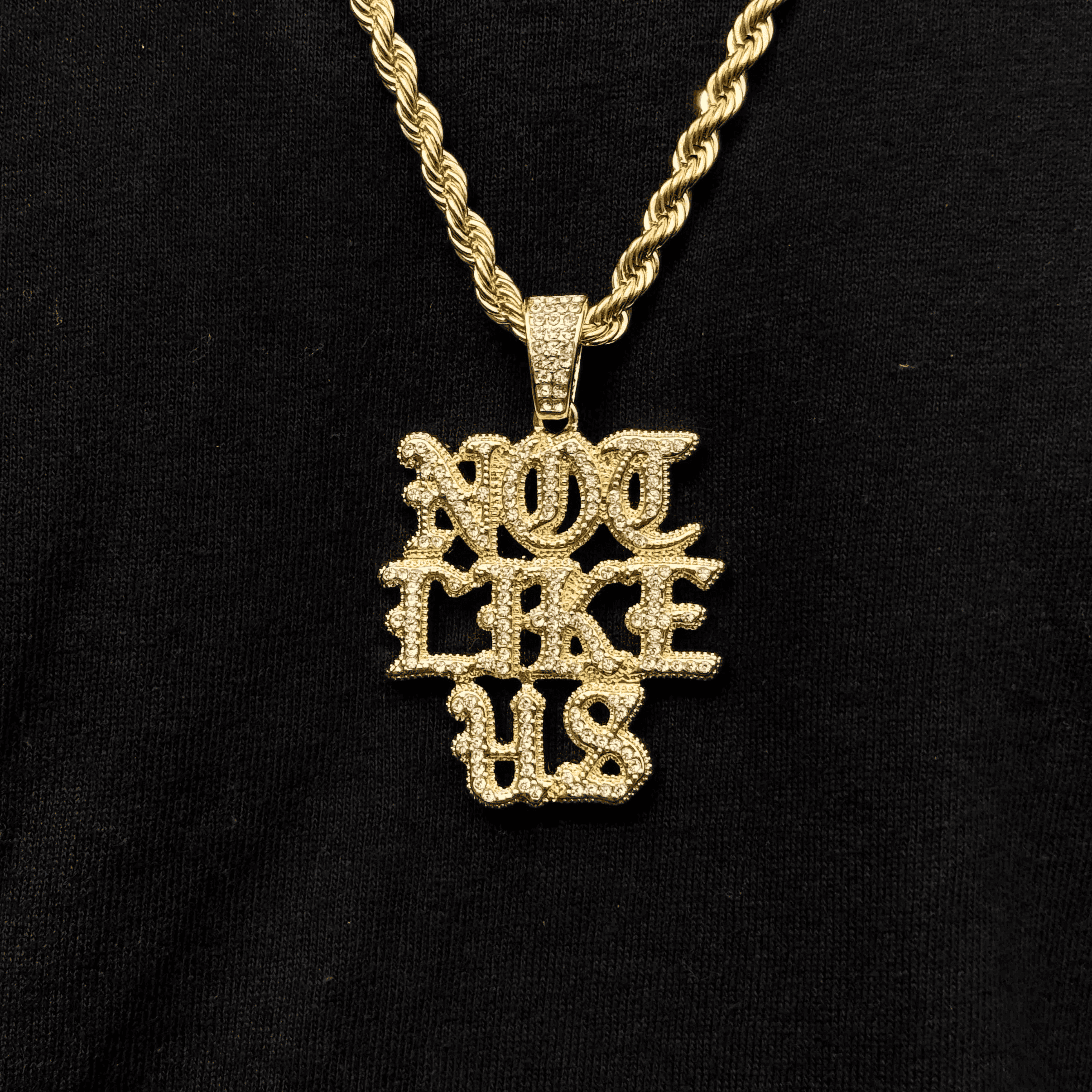 Gold iced out Not Like US pendant for men styled on a 4mm rope necklace hip hop chain.