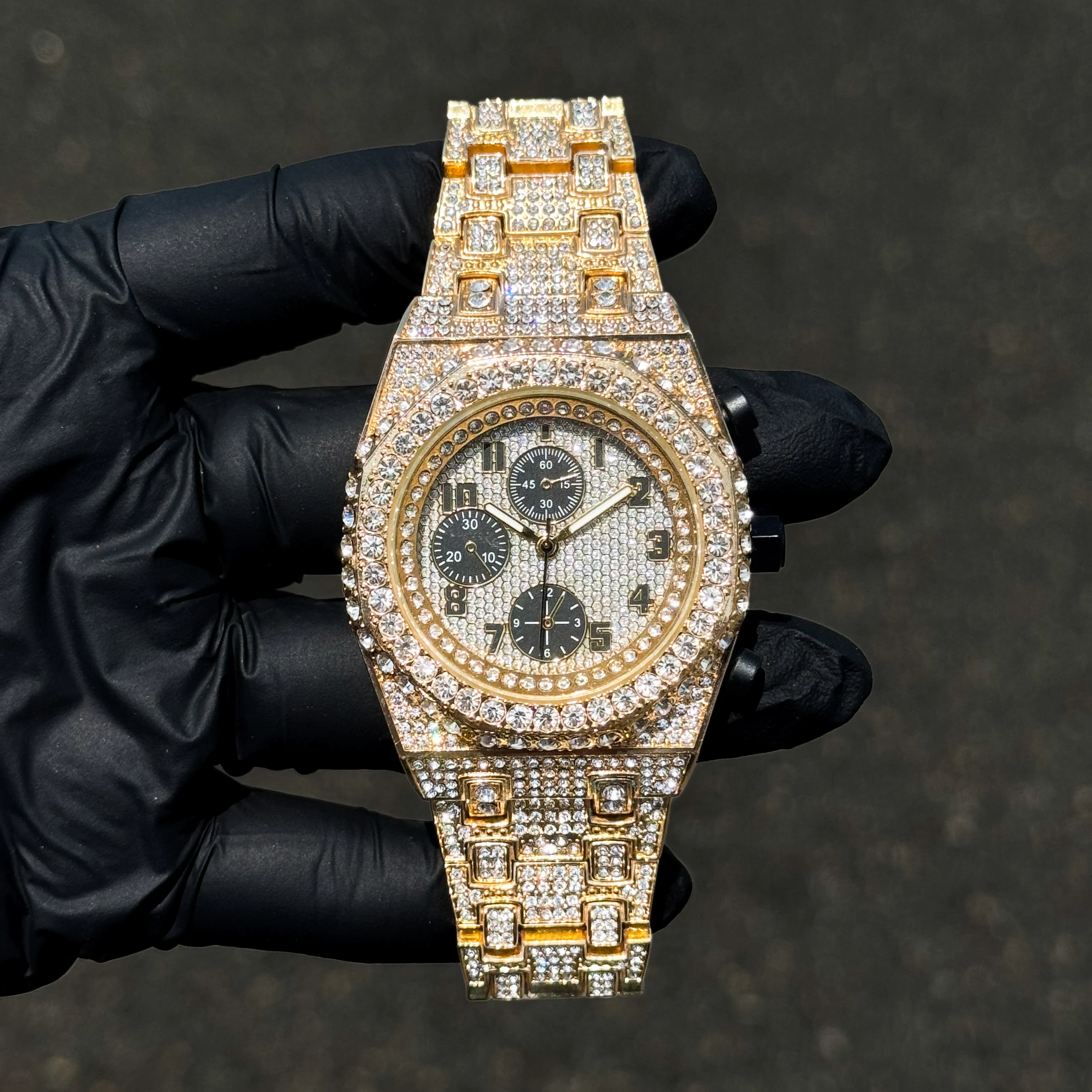 Men's 42mm gold fully iced out diamond watch with octagon case and crystal link bracelet.