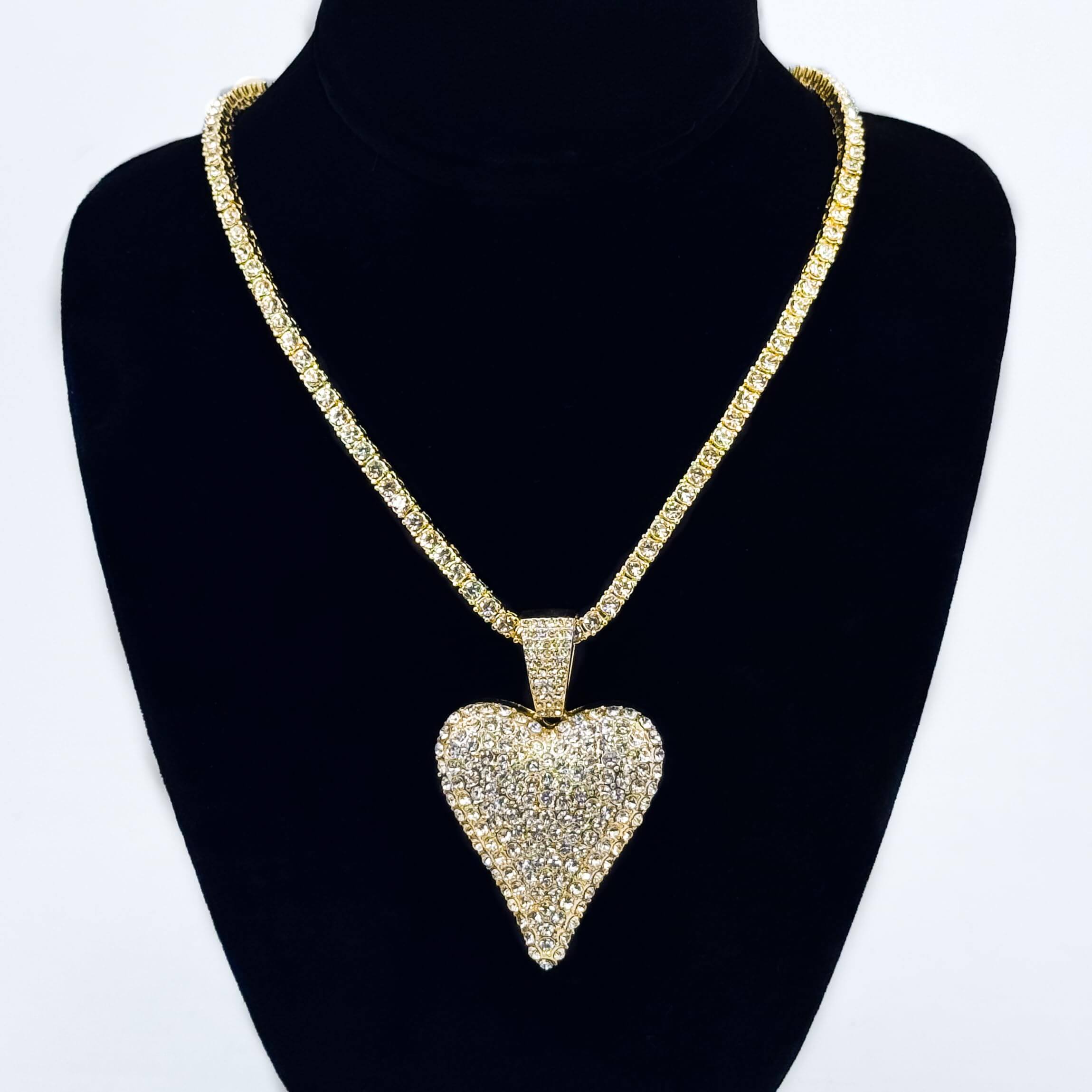 Ladies 40mm iced-out gold heart pendant necklace with 4mm tennis chain displayed on jewelry bust.