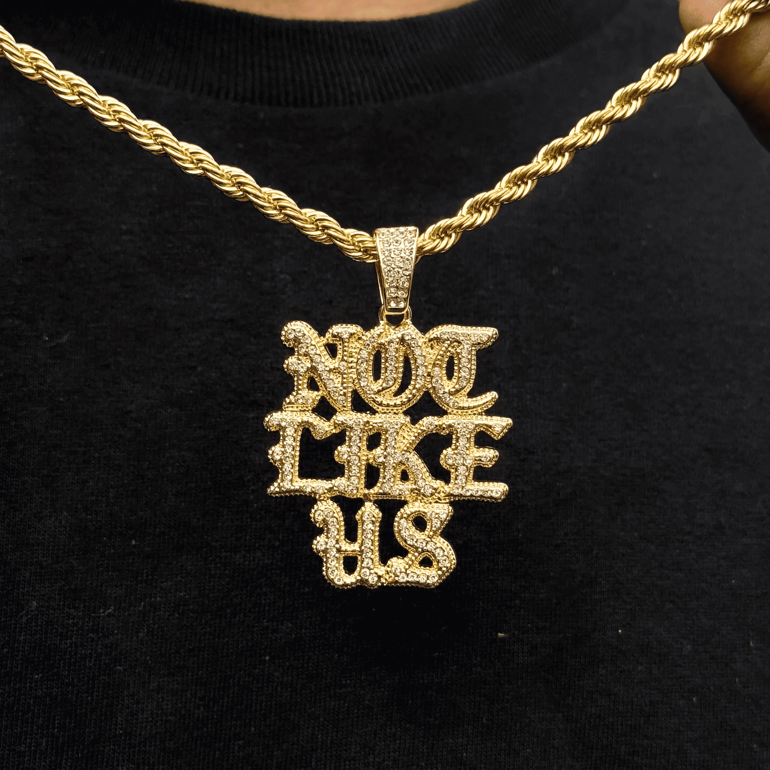 Gold Men's Medium Not Like US pendant with iced out stones on a 4mm rope chain necklace.