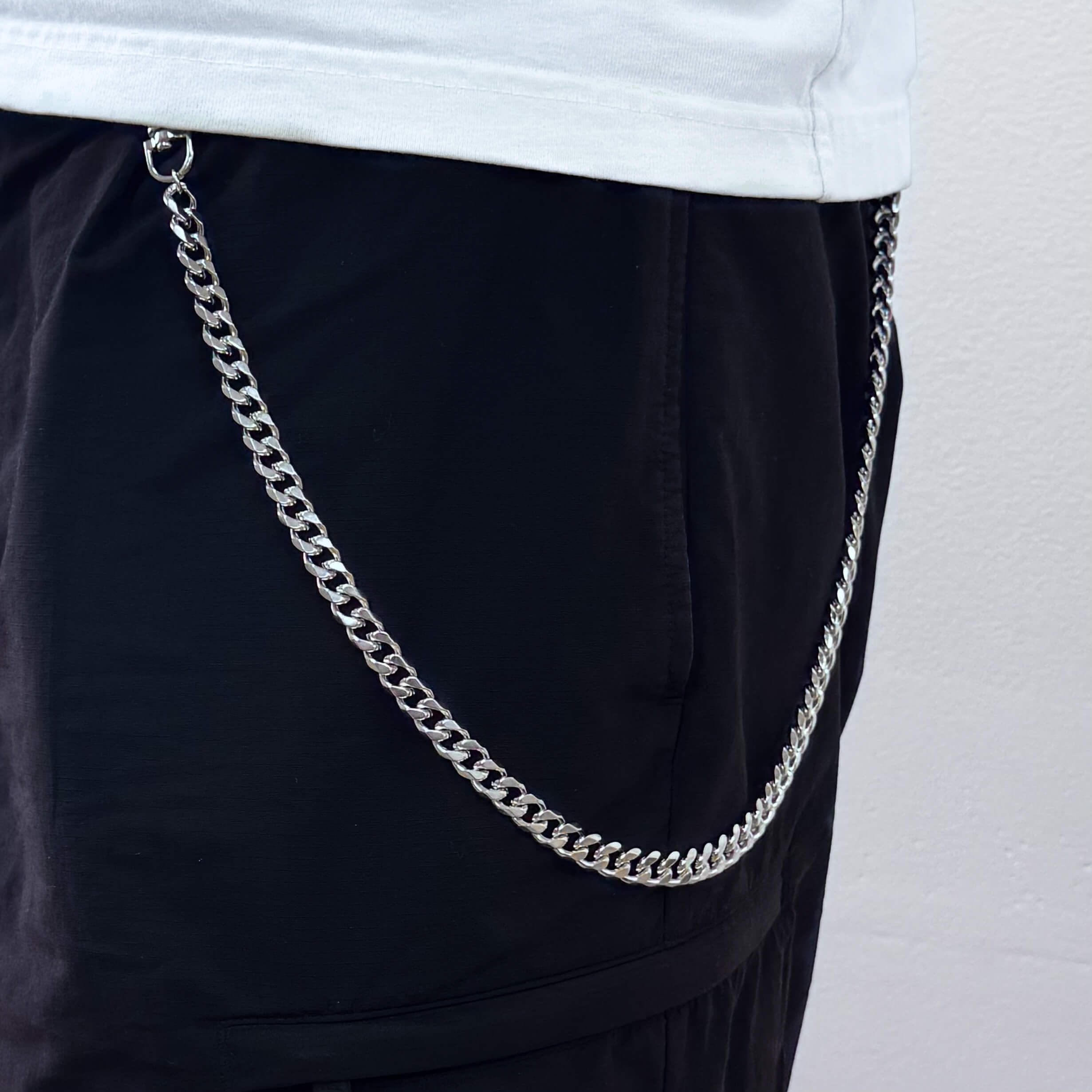 Silver solid 10mm Cuban link pant chain worn with black pants, a bold streetwear accessory.