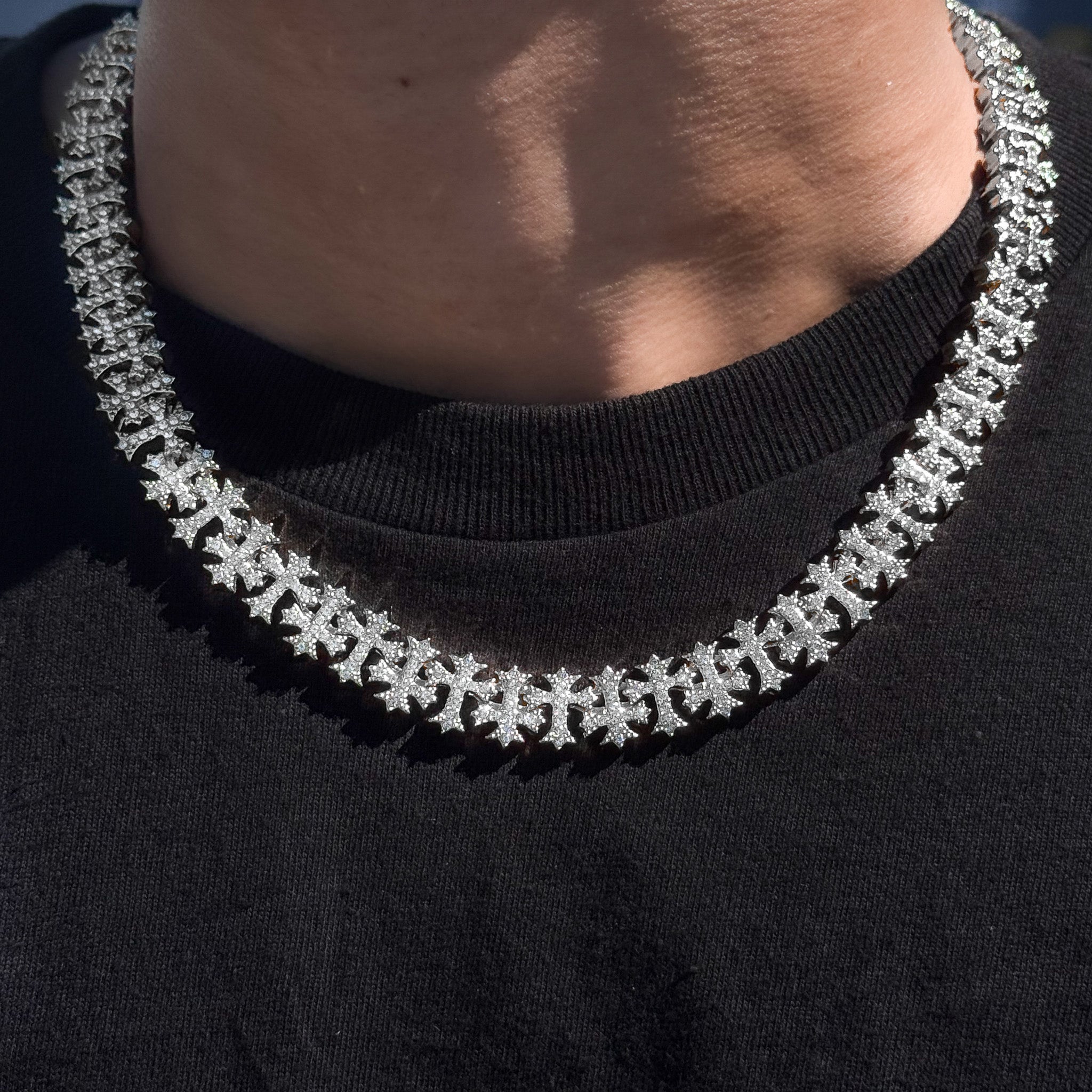 Men's 20mm iced out cross link chain necklace in silver, shown worn to highlight shine and detail.