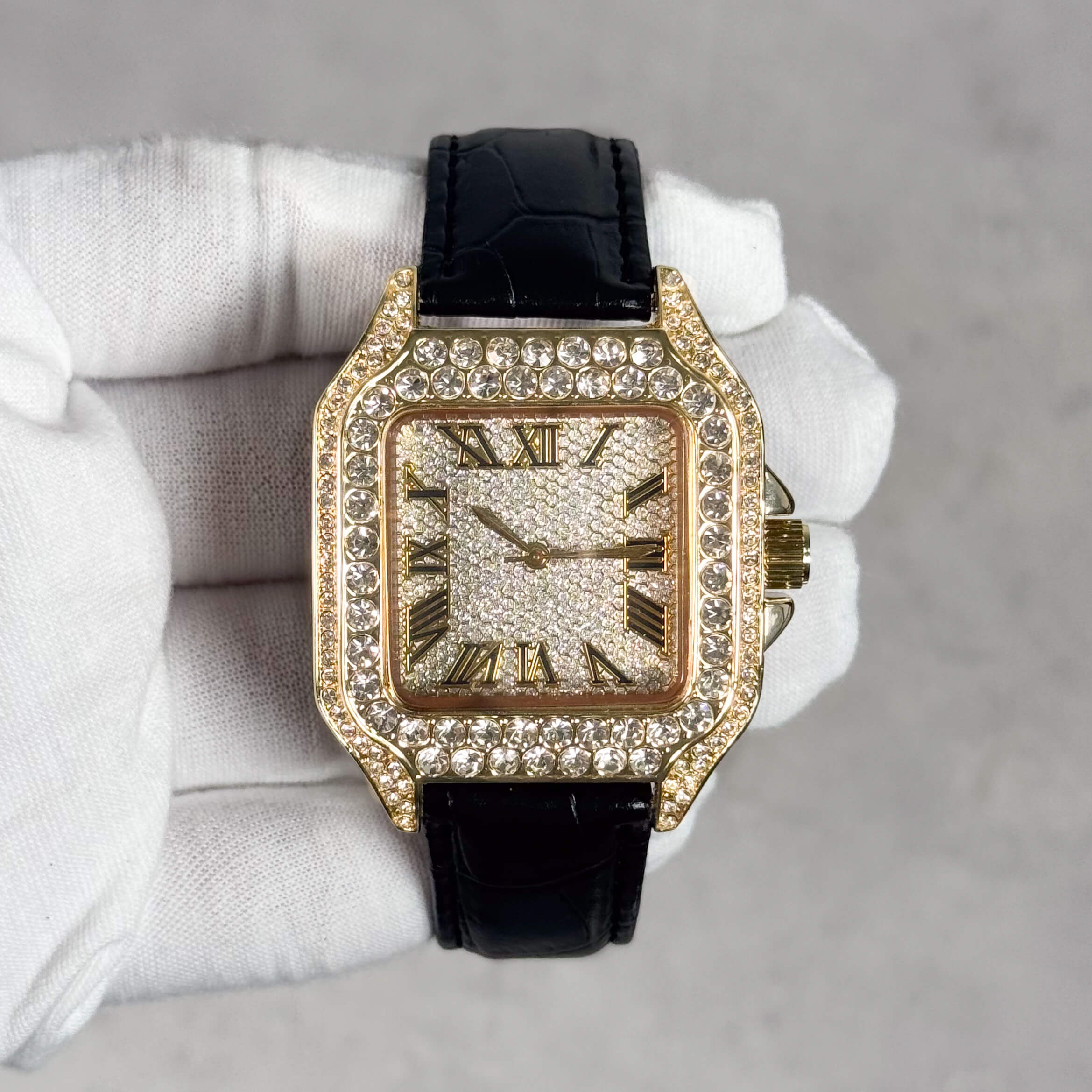 Men's 32mm gold iced out square dial watch with crystal bezel and black leather band front view.