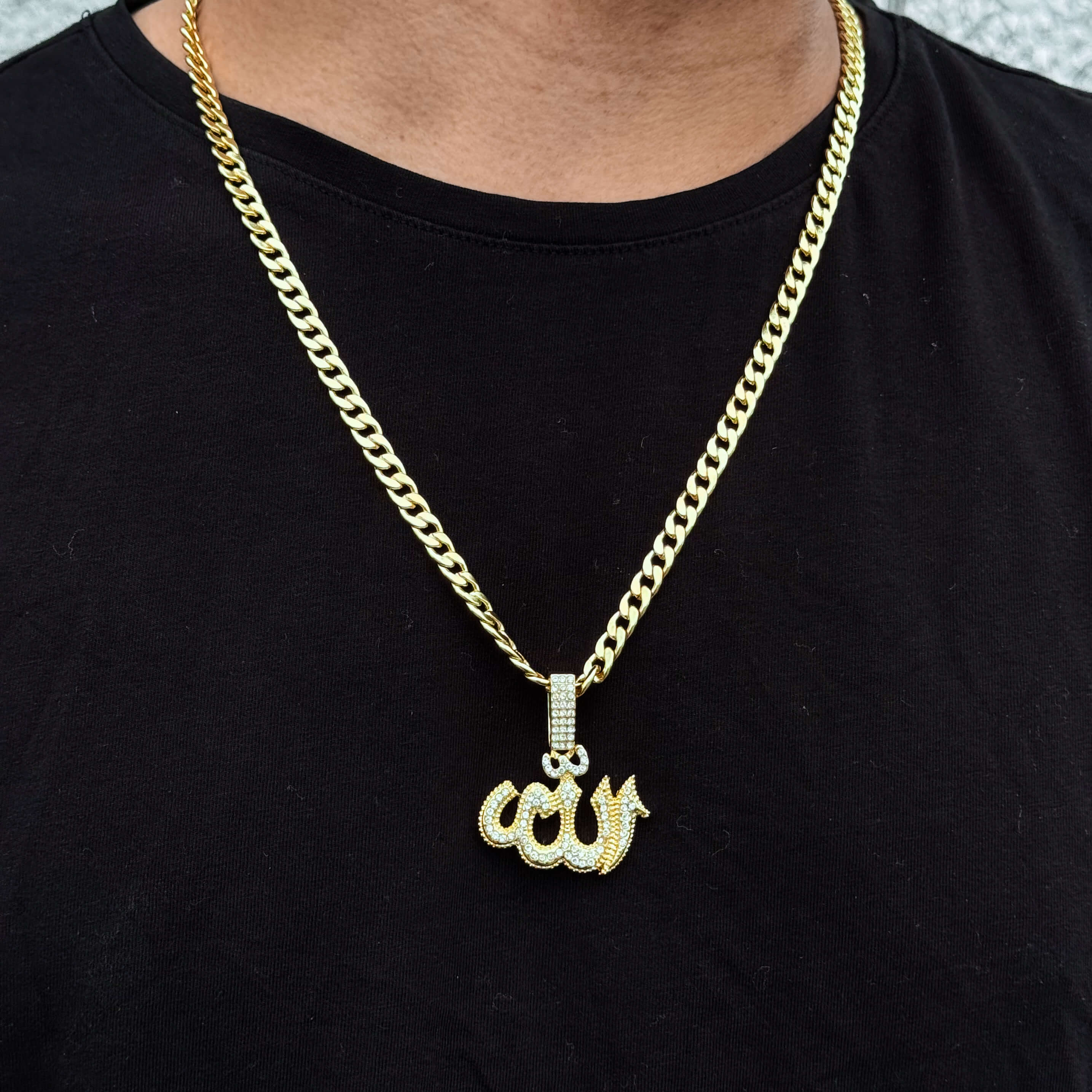 Gold Allah pendant worn on model with 6mm Cuban chain, featuring 35mm iced-out Arabic design.