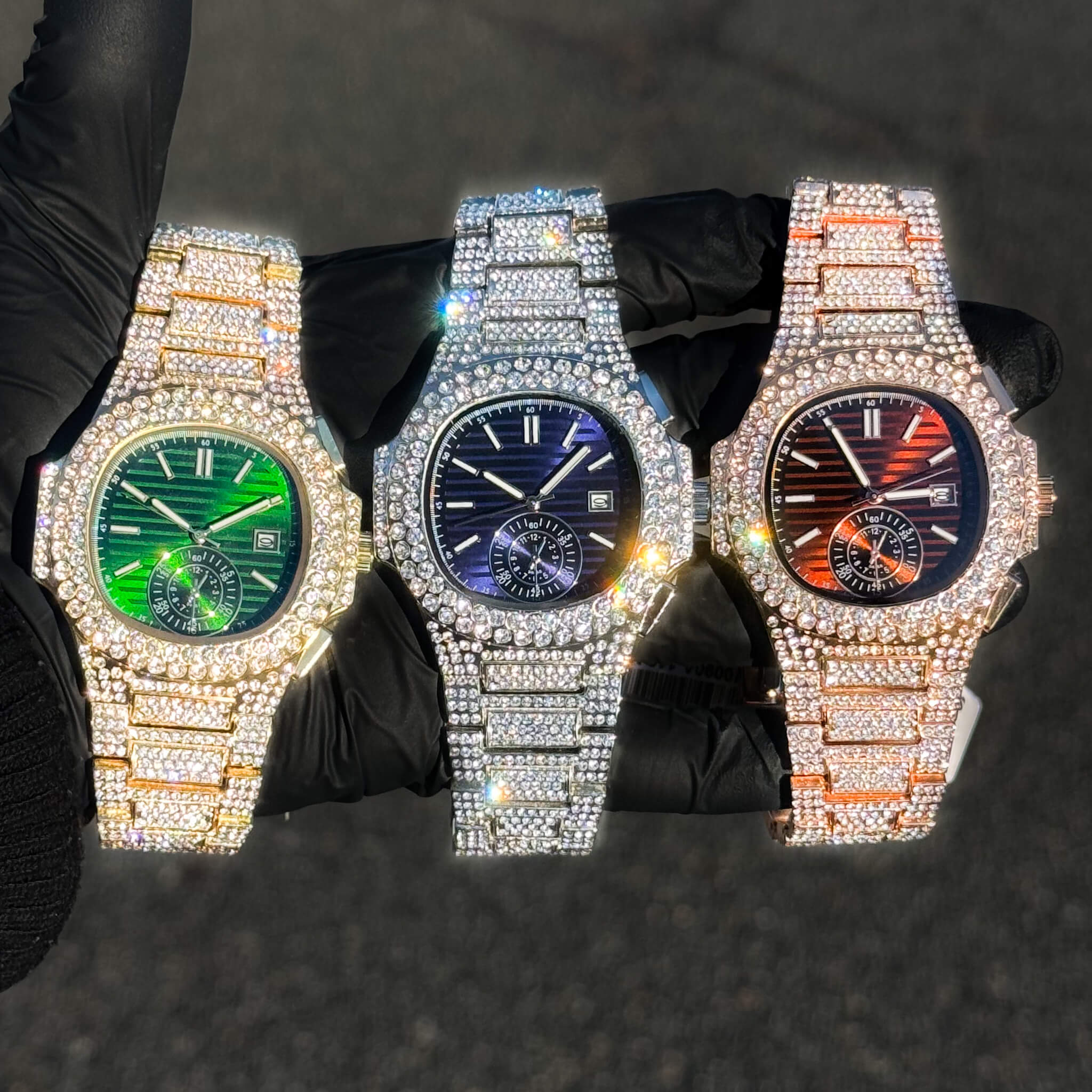 Men's 43mm iced out oblong watches with green, blue, and red dials and full diamond settings.