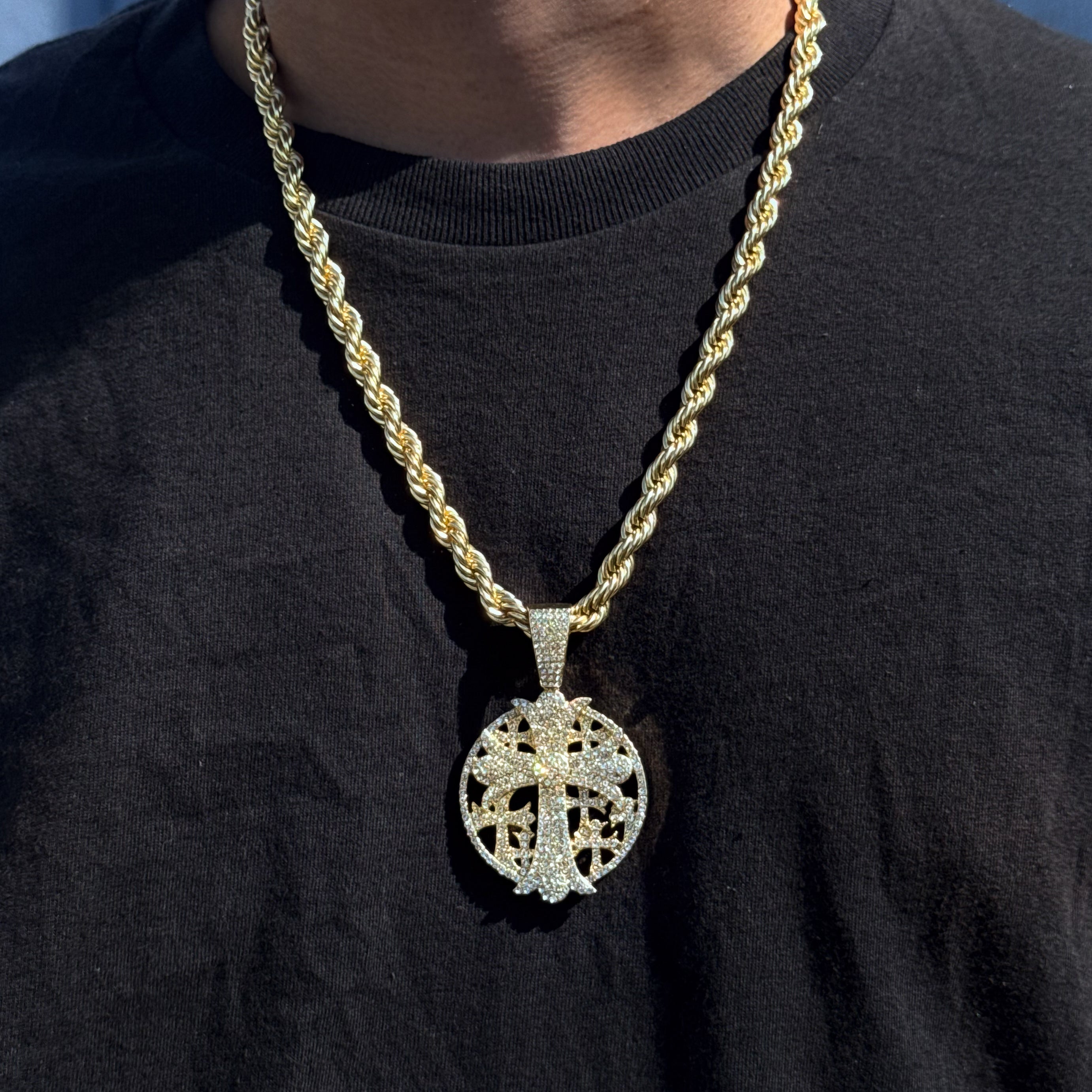 Men’s 44mm silver iced-out cross medallion pendant with 8mm rope chain worn over black shirt.
