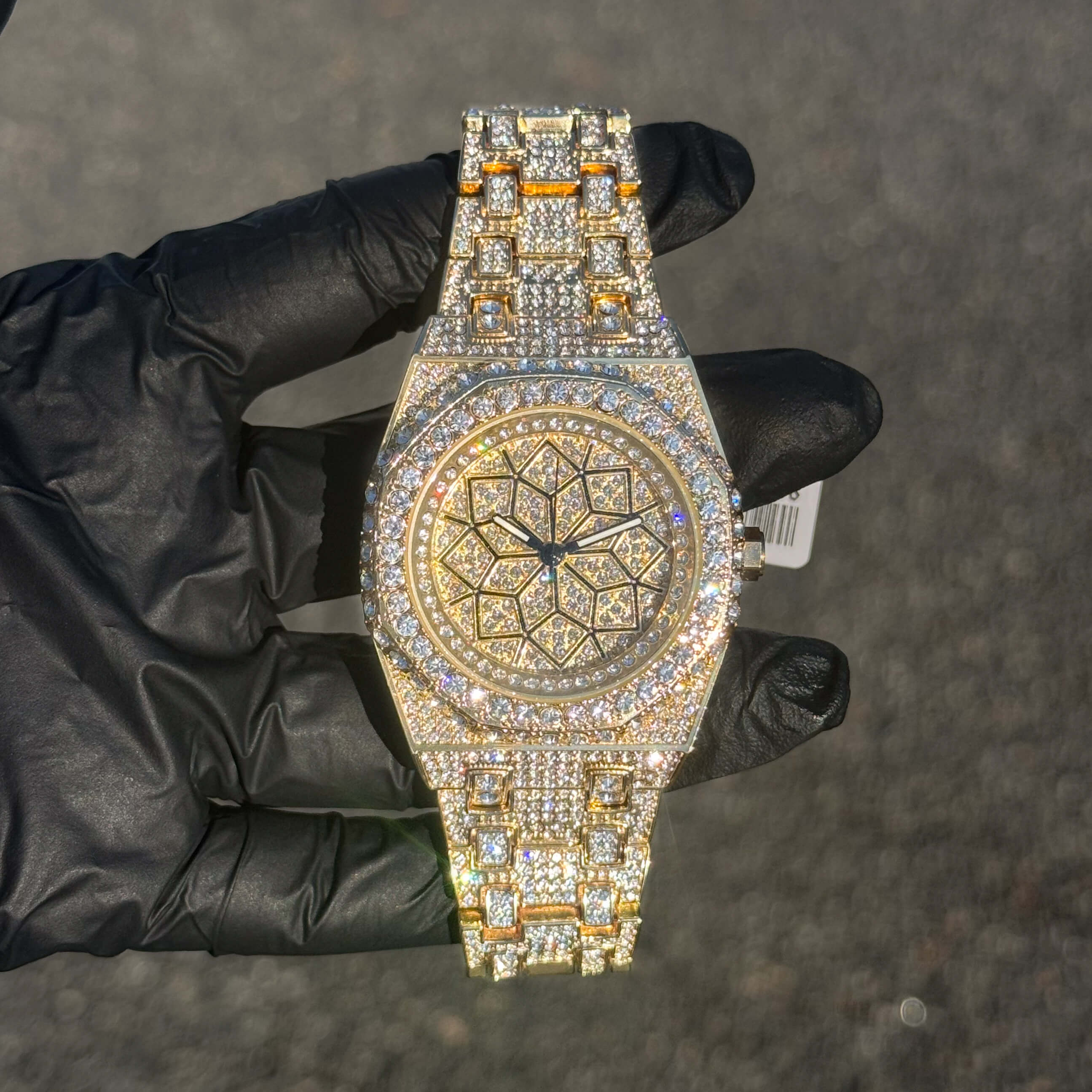 Men's 43mm gold iced out octagon shape watch with full crystal bezel and patterned dial.