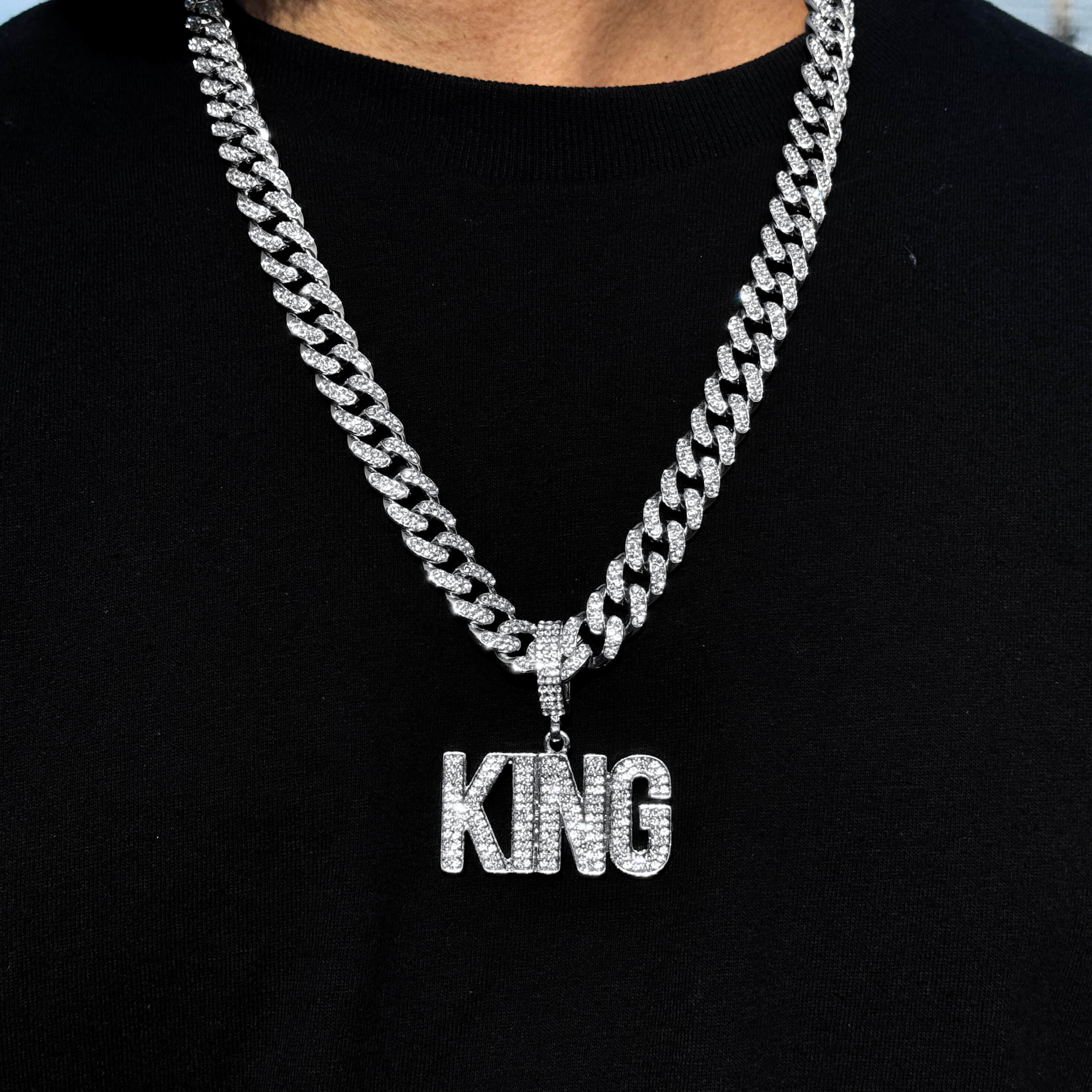 Men's silver iced-out KING pendant with 12mm Cuban chain, bold hip hop necklace featuring pavé stones.