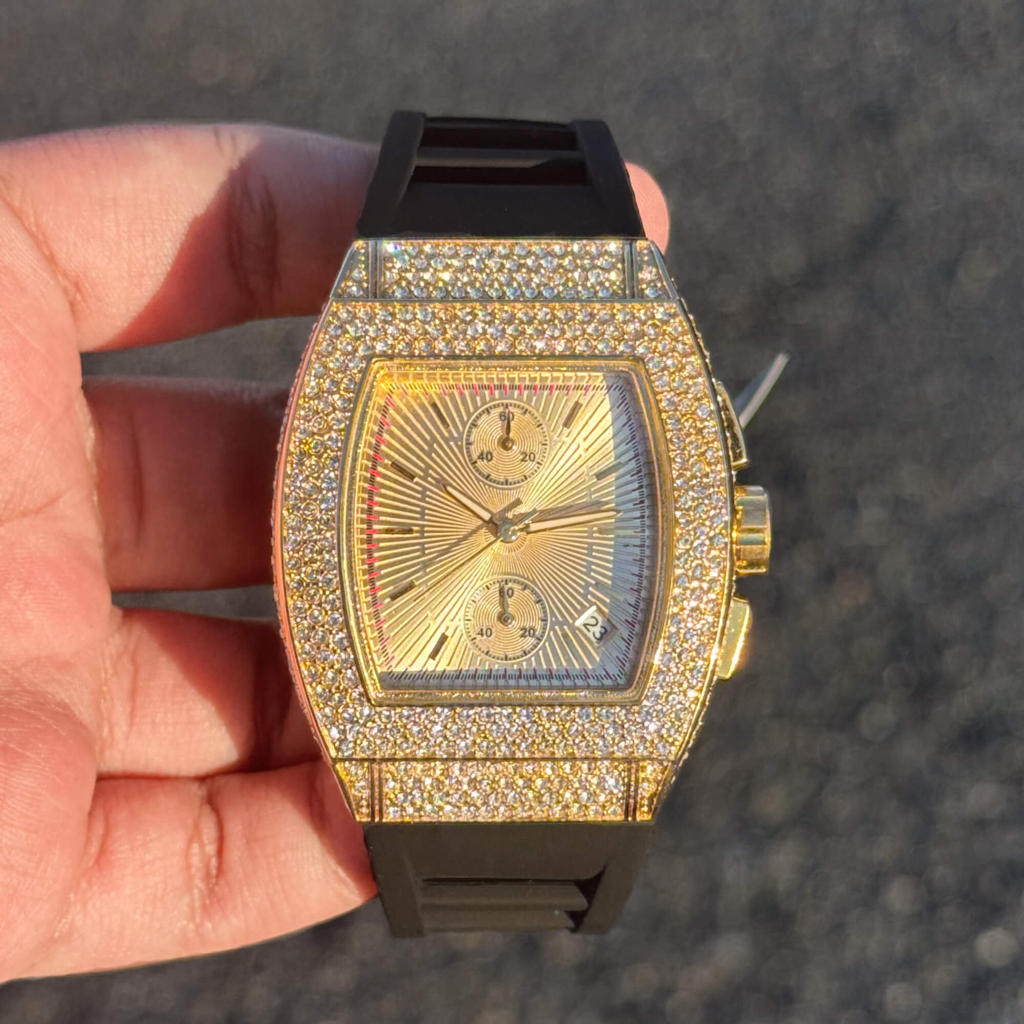 Men's Luxury Iced 39mm Tonneau Watch in gold with diamond bezel and black silicone band.