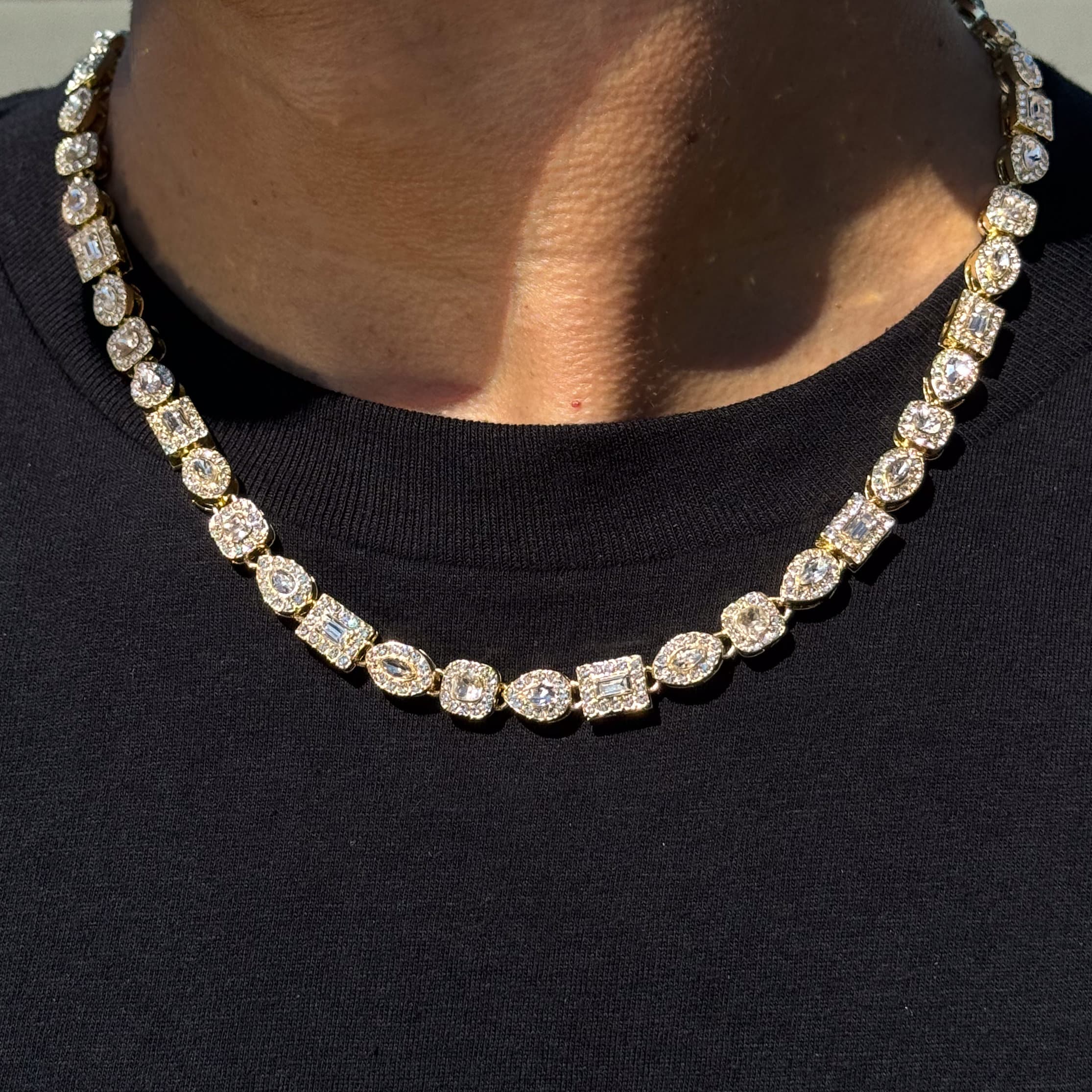 Men's Iced Out 6mm Mixed Stone Cluster Chain Necklace in gold with multi-shape diamond-cut stones shown on model.