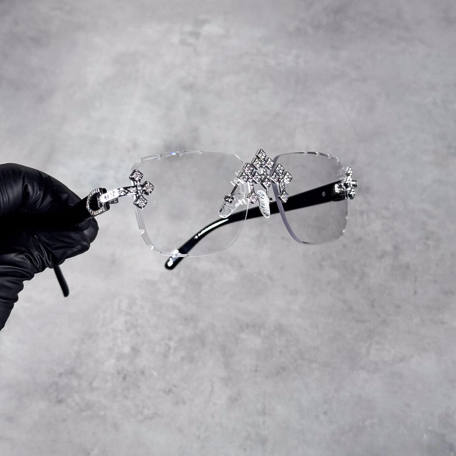 Clear lens Triple Cross sunglasses featuring black arms and shimmering diamond cross décor.