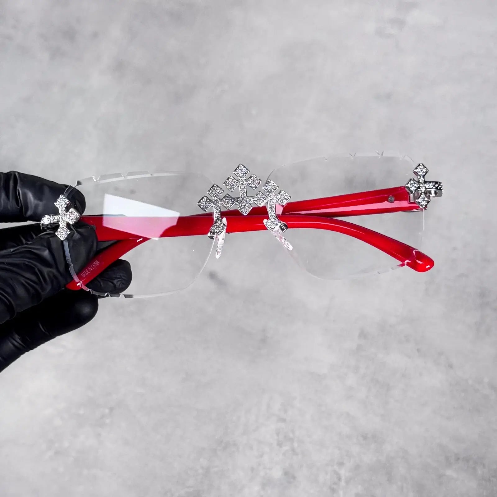 Clear lens Triple Cross Sunglasses with bold red temples and shimmering crystal cross accents.