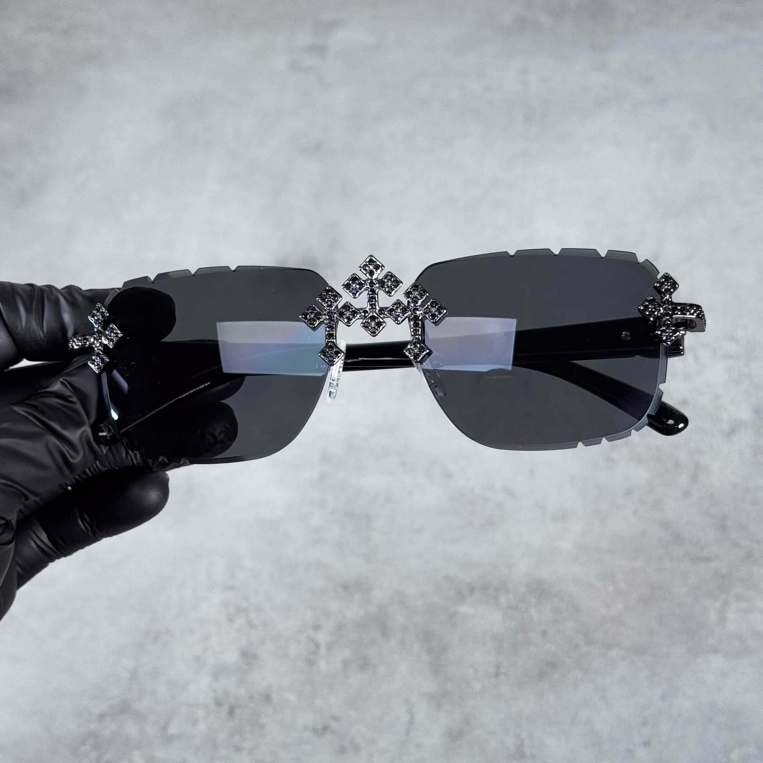 Iced Triple Cross Sunglasses with jet black lenses and crystal cross accents on rimless frame.