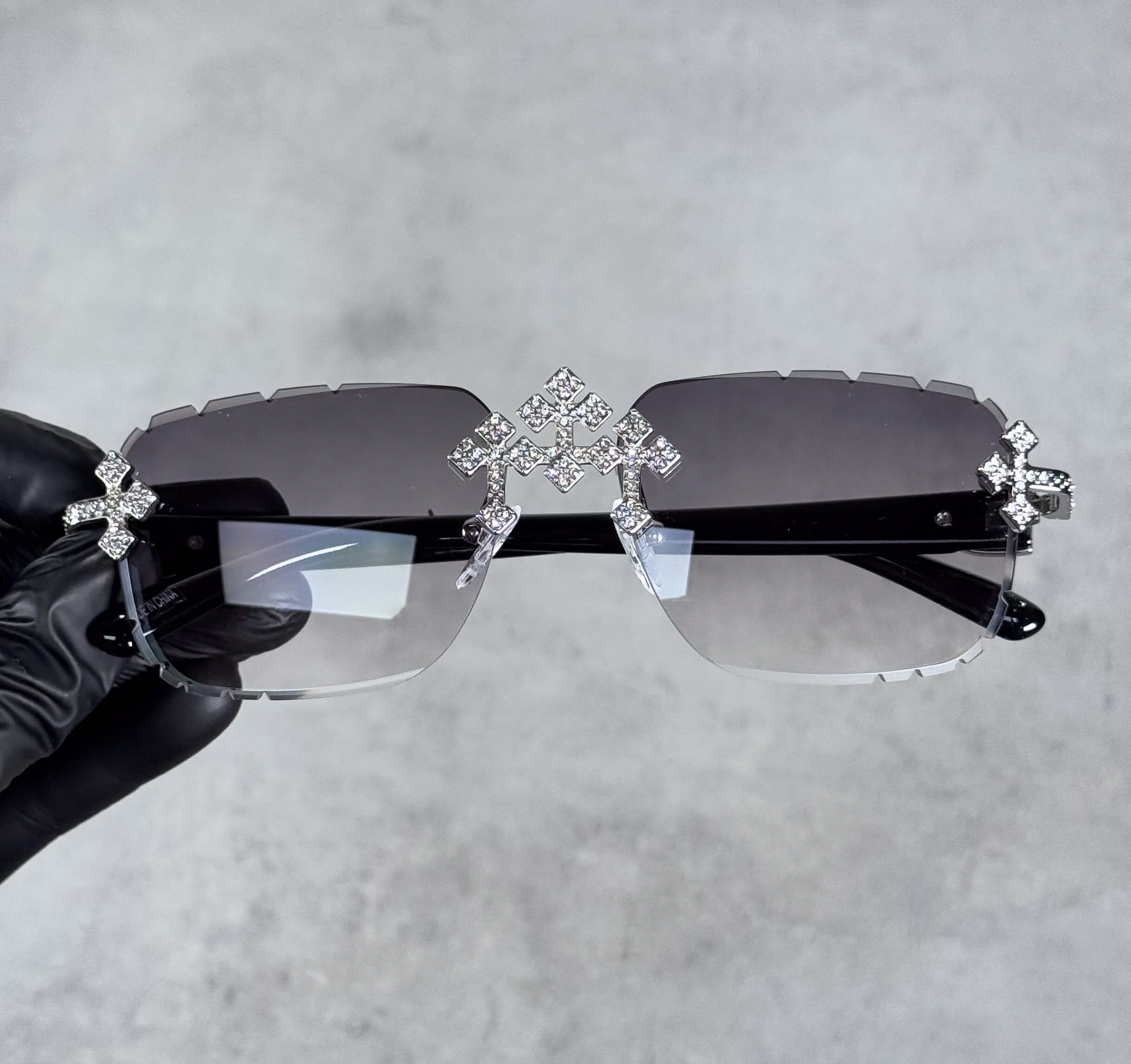 Iced Triple Cross Sunglasses with smoke gradient lenses and crystal cross accents on rimless frame.