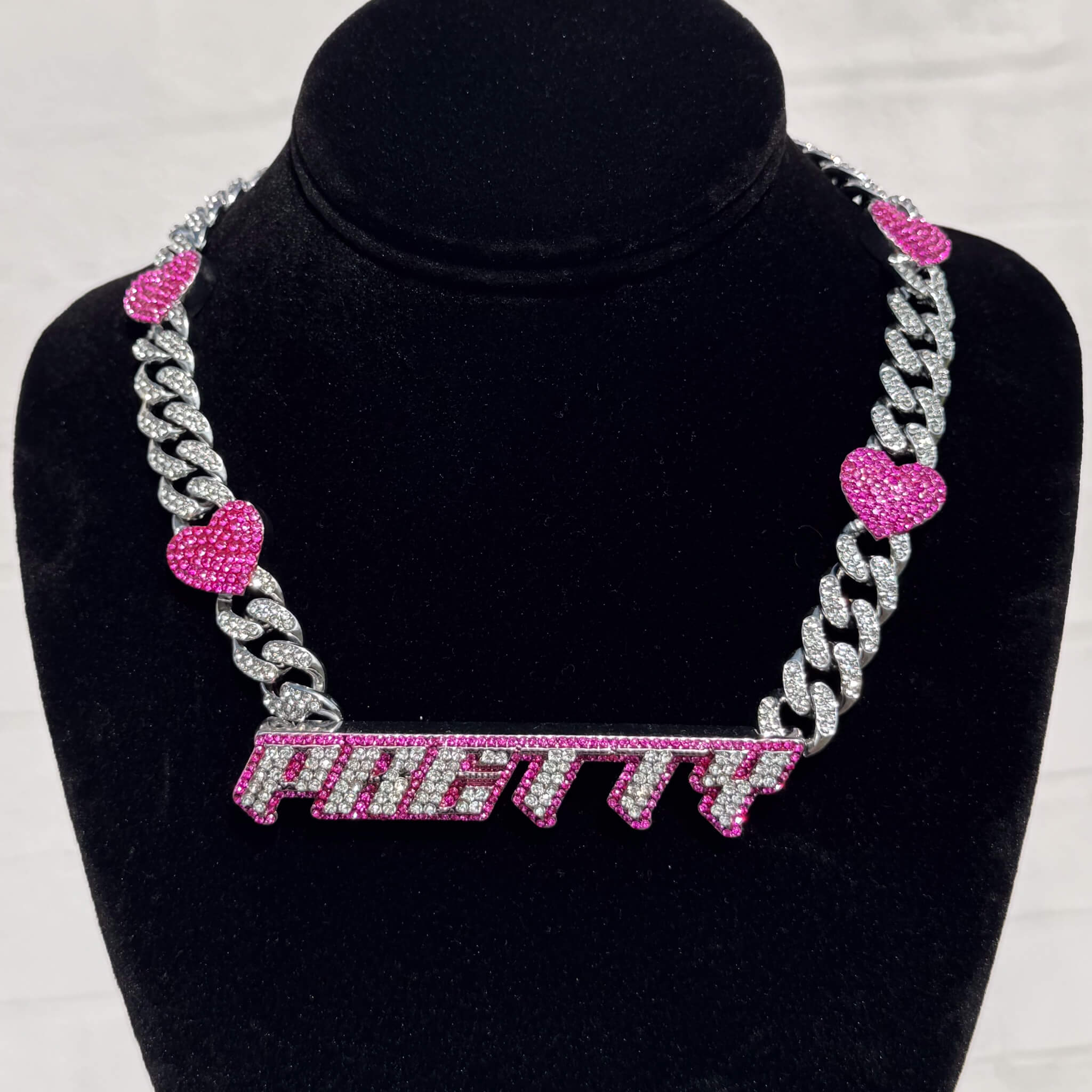 Pretty Pink Heart Cuban Choker with iced silver links and pink heart accents on display stand.