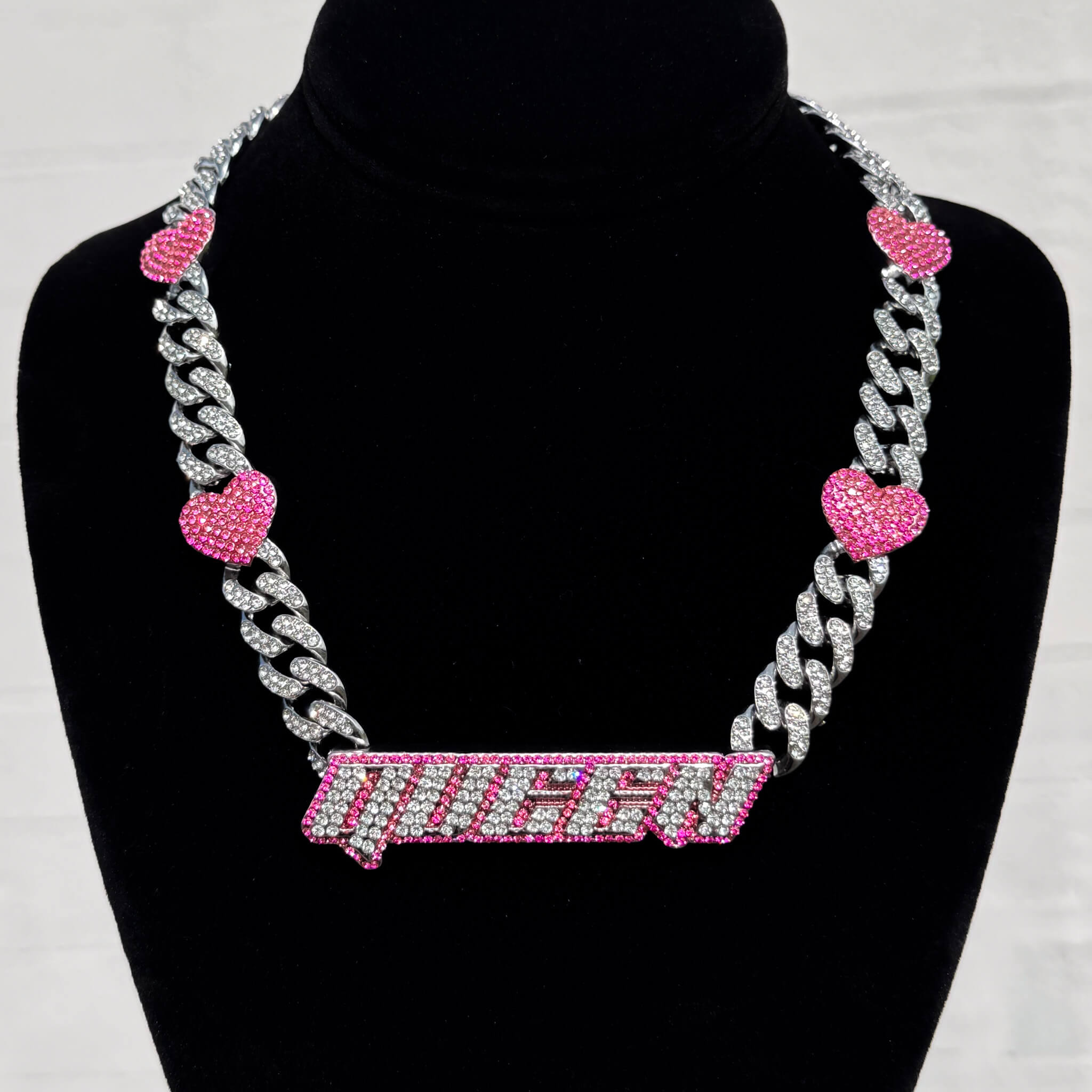 Queen Pink Heart Cuban Choker with iced silver links and pink heart accents on display stand.