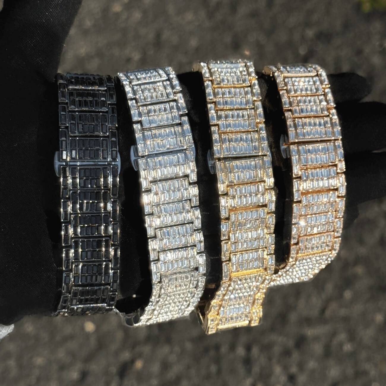 Four iced out baguette watch bands in black, silver, gold, and rose gold luxury finishes