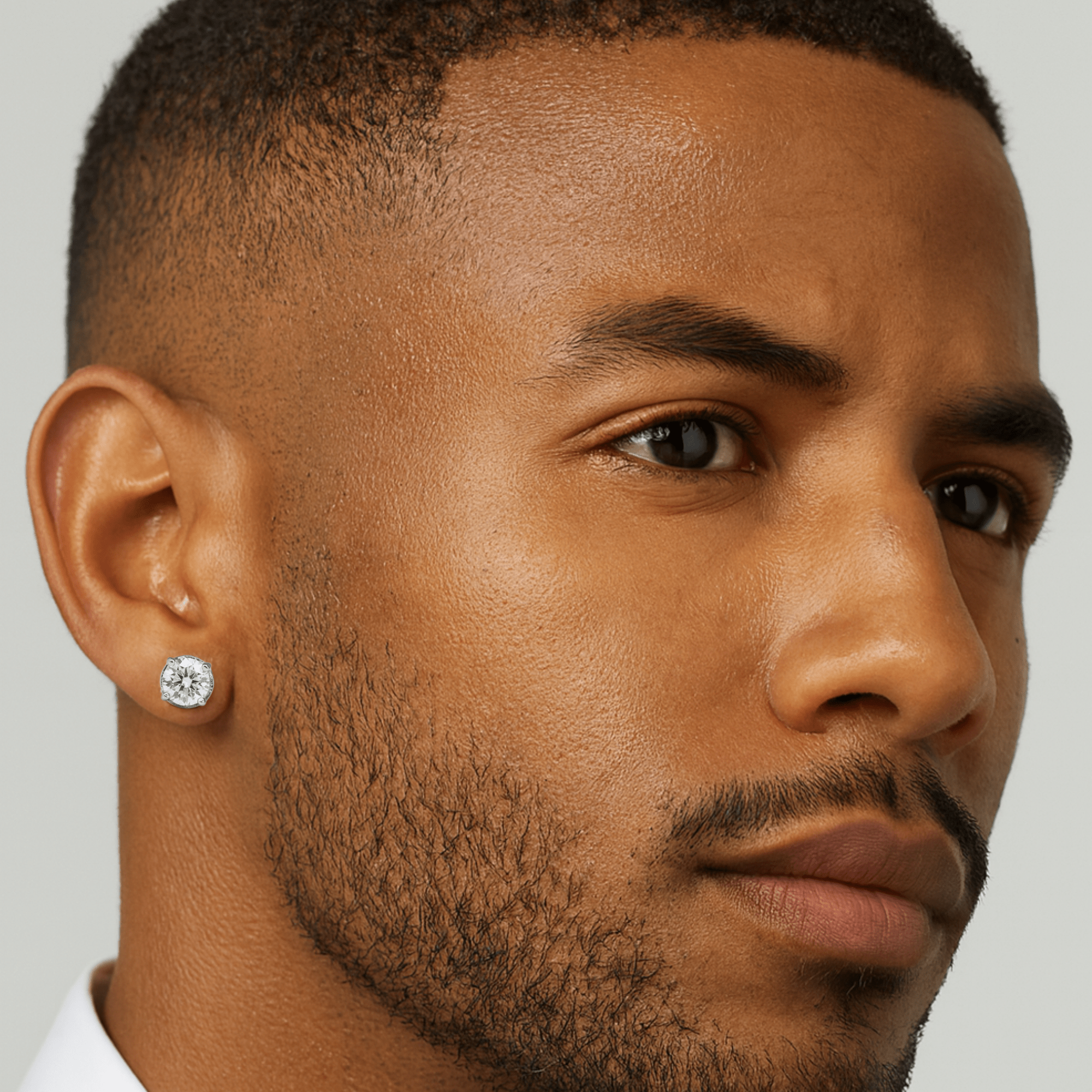 Male model wearing 5mm round Moissanite solitaire earrings, showcasing bright silver diamond studs.