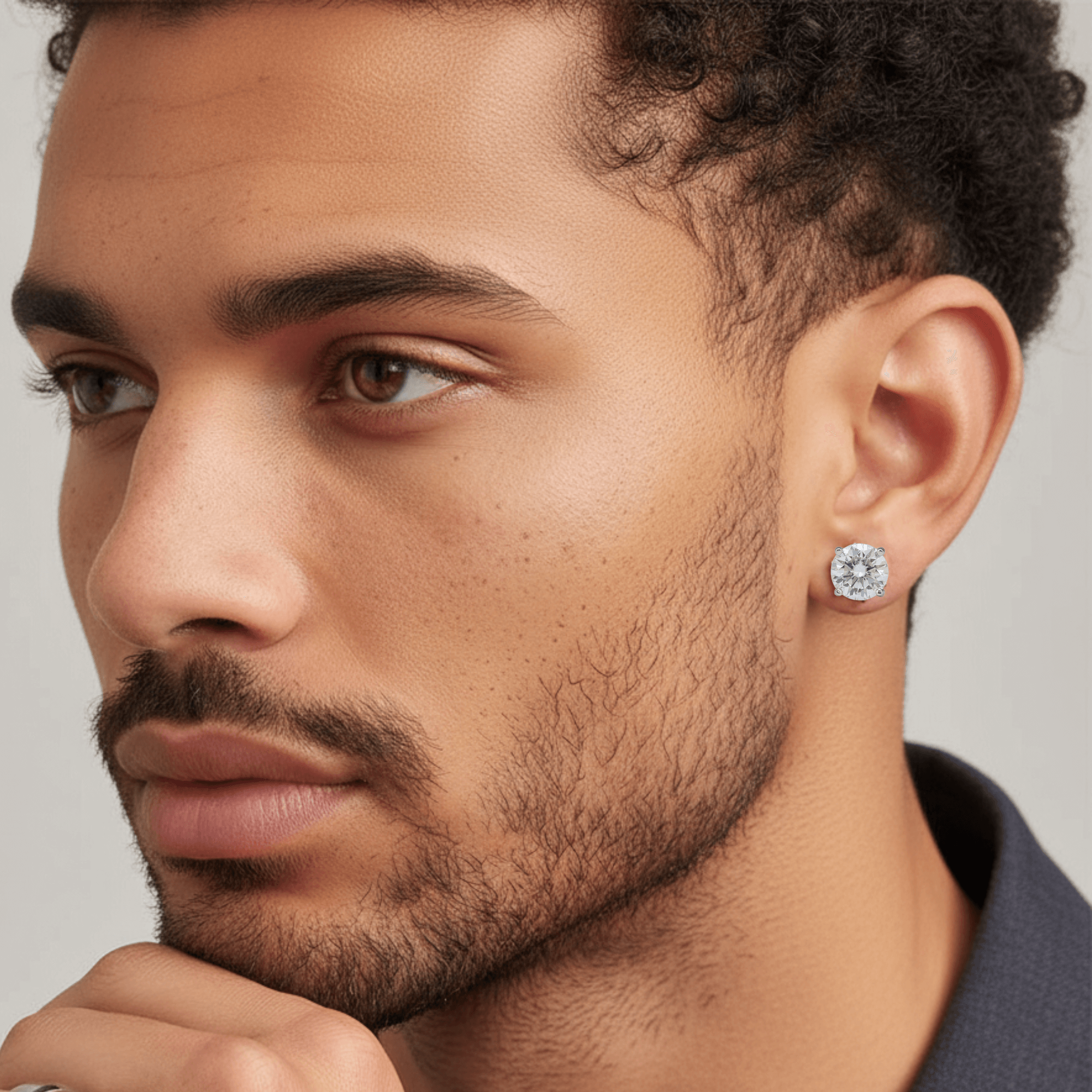 Man wearing 8mm round moissanite solitaire earrings showcasing bright 3.2ct sterling silver stud design.