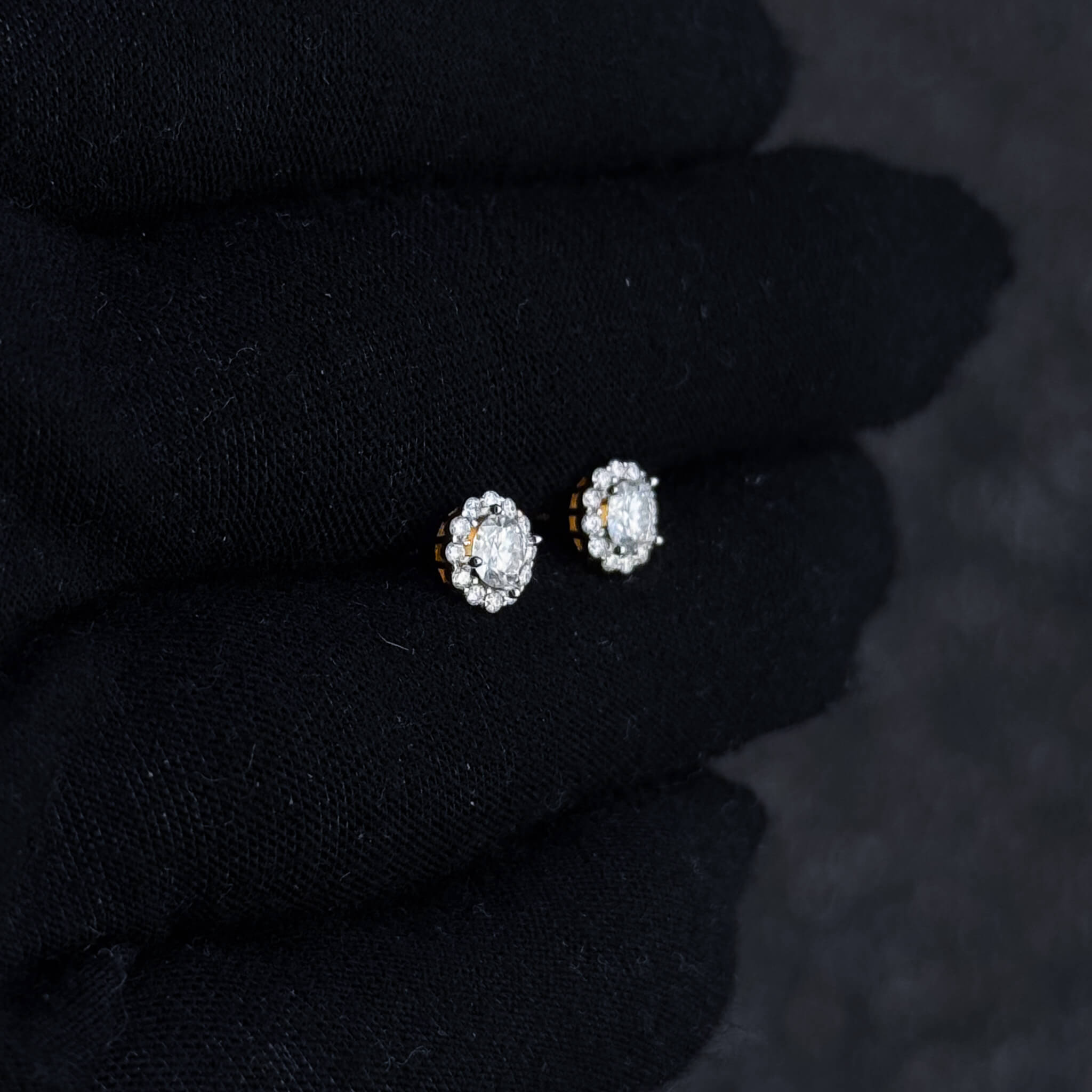 Small 7mm Moissanite cluster diamond stud earrings shown on black glove in sterling silver setting.
