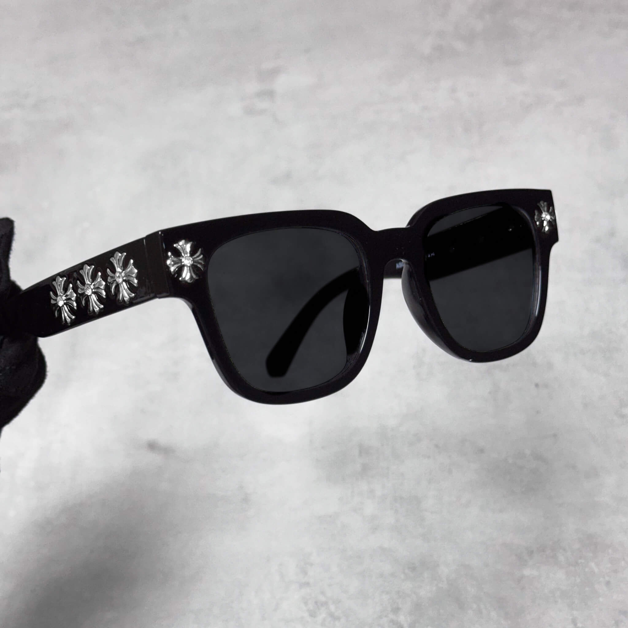 Side angle of black Cross Chrome Inspired Sunglasses featuring silver cross details on temples.