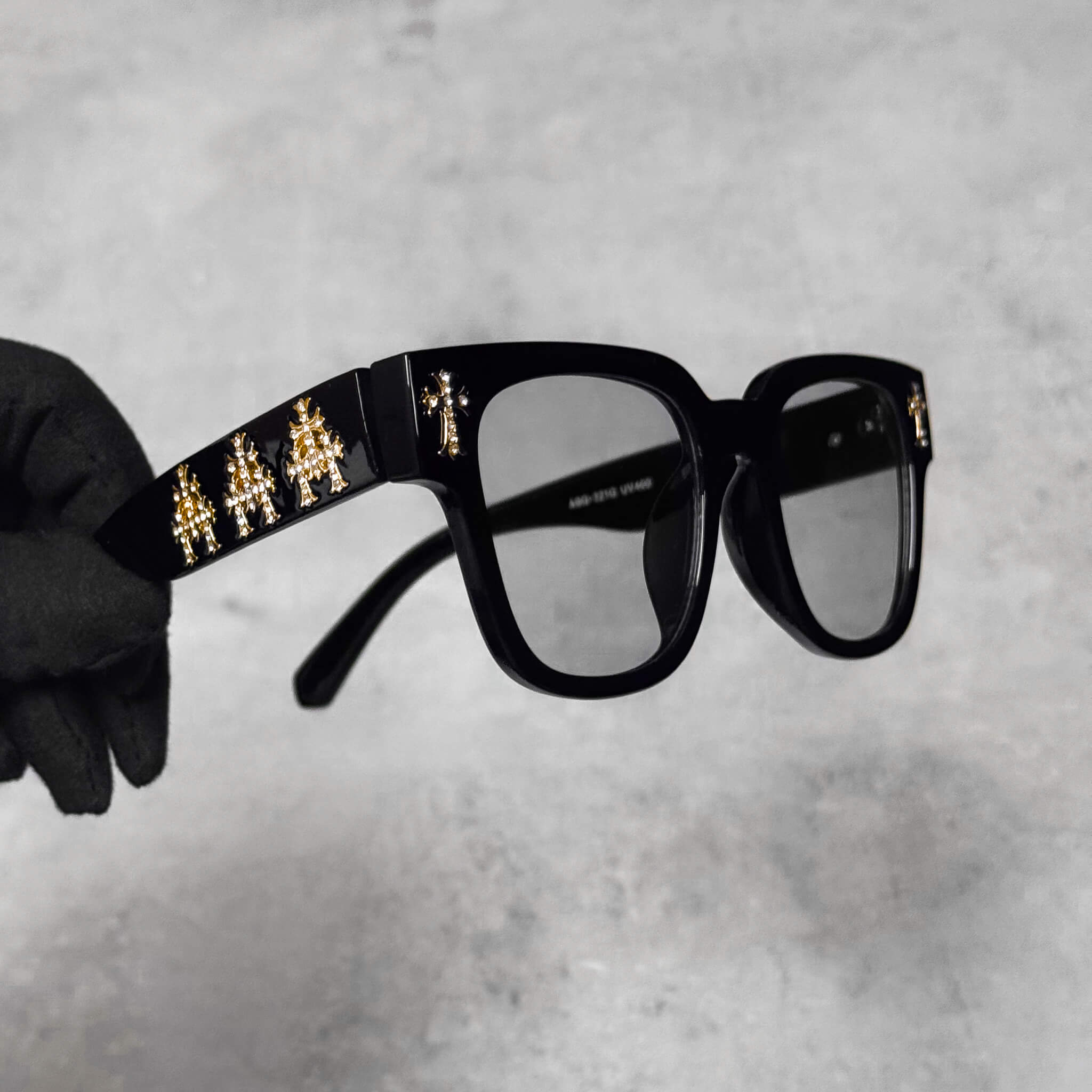 Side view of Triple Cross Chrome Inspired Sunglasses with gold triple-cross embellishments on temples.