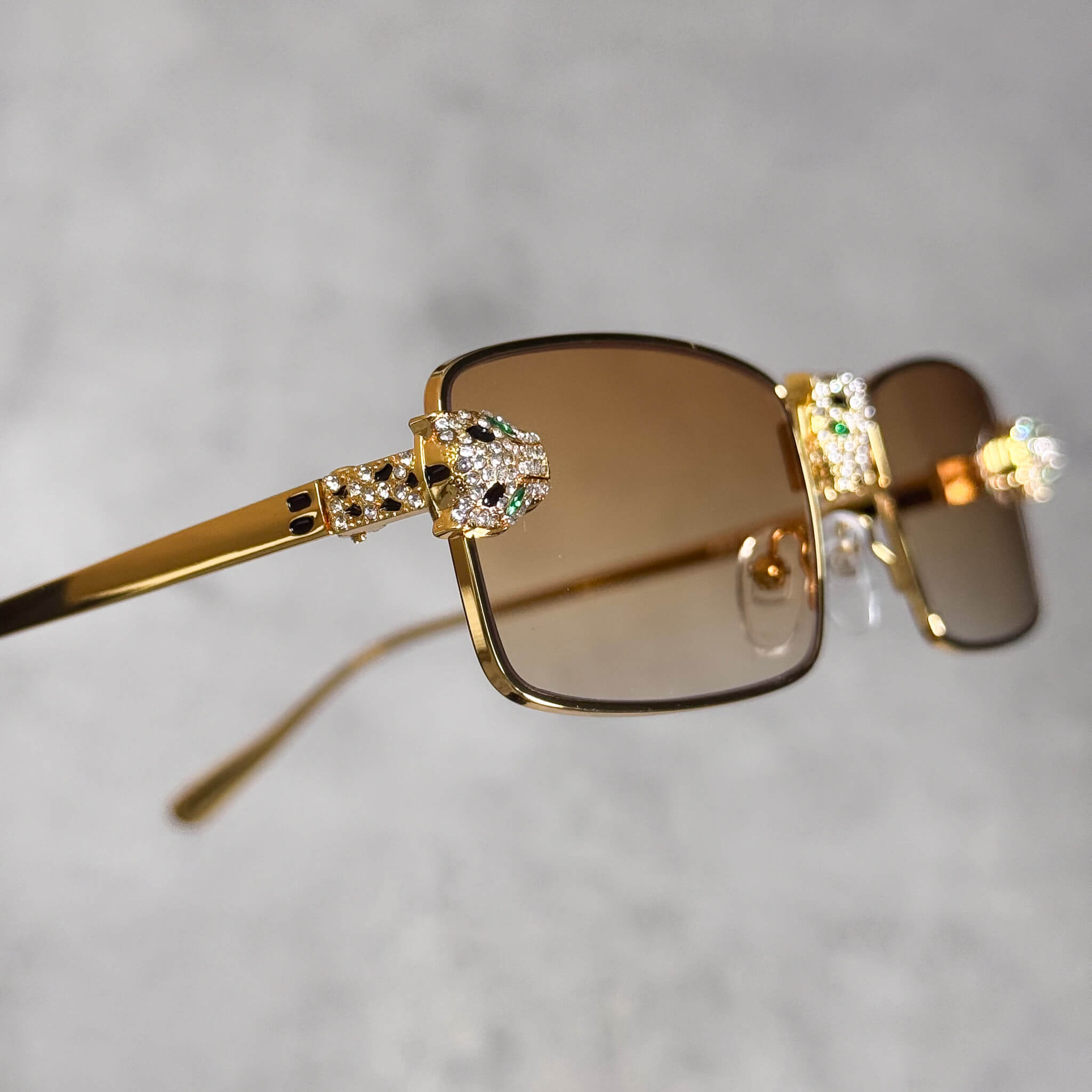 Side angle of gold Iced Out Panther Sunglasses with yellow lenses and jeweled panther trim.