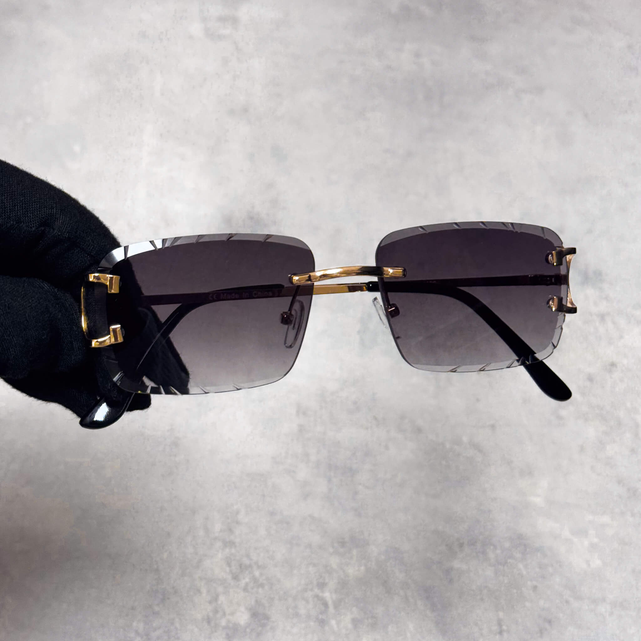 Gold-trim smoke lens sunglasses featuring cut-edge square frames and luxe metal detailing.