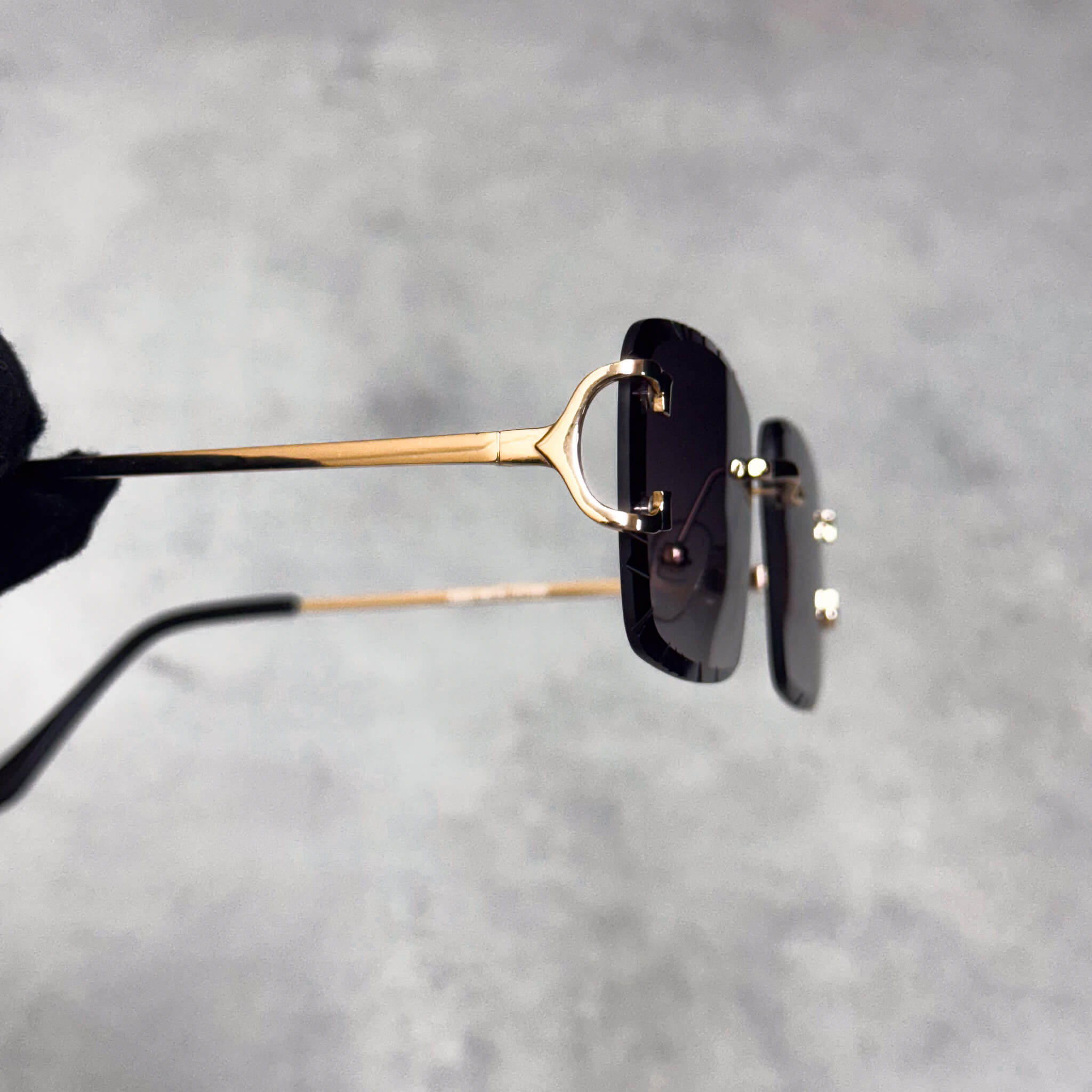Gold metal temple detail on smoke cut-edge sunglasses with squared gradient lenses.