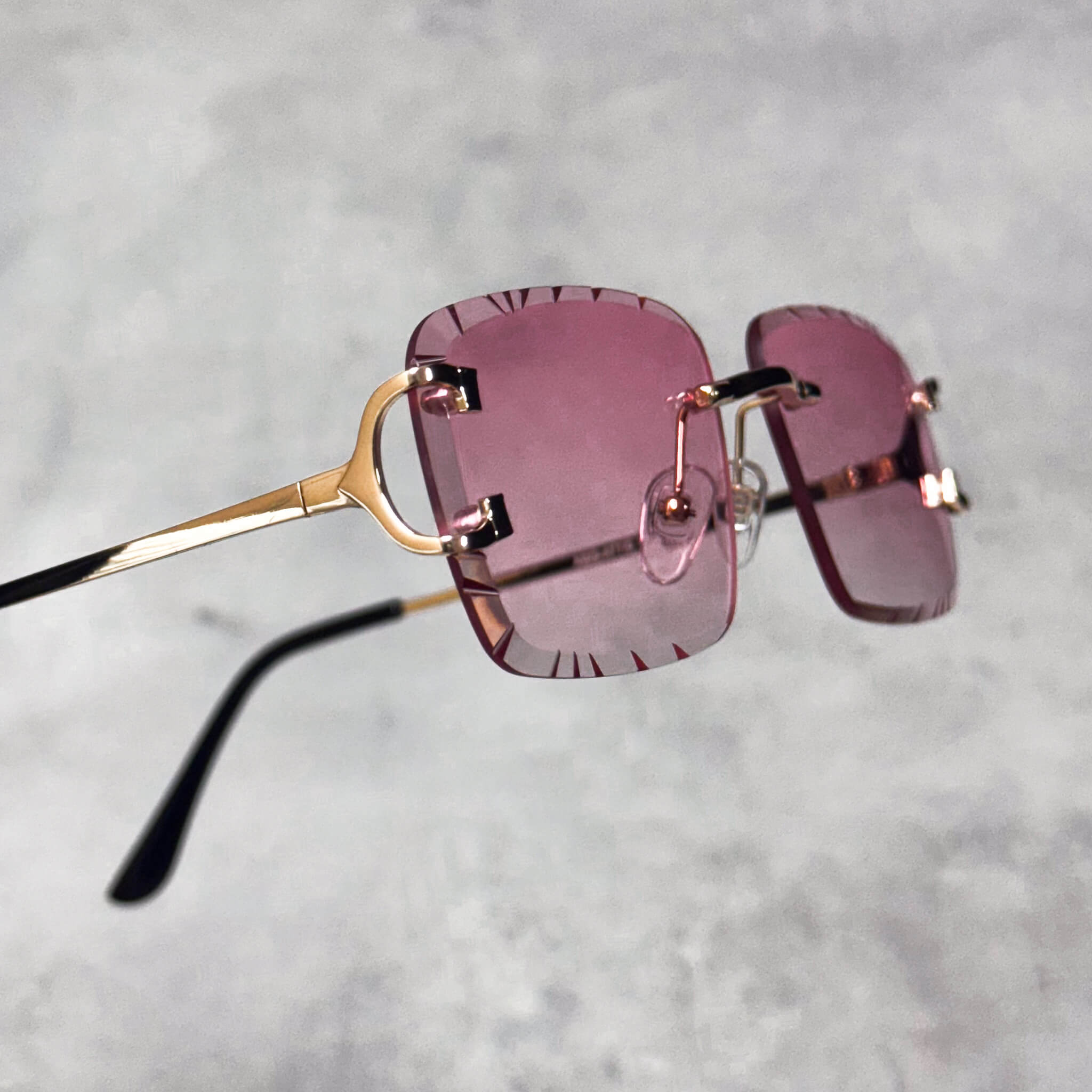 Pink-lens Solid Cut-Edge Sunglasses shown from side, with gold hinge detail and square frames