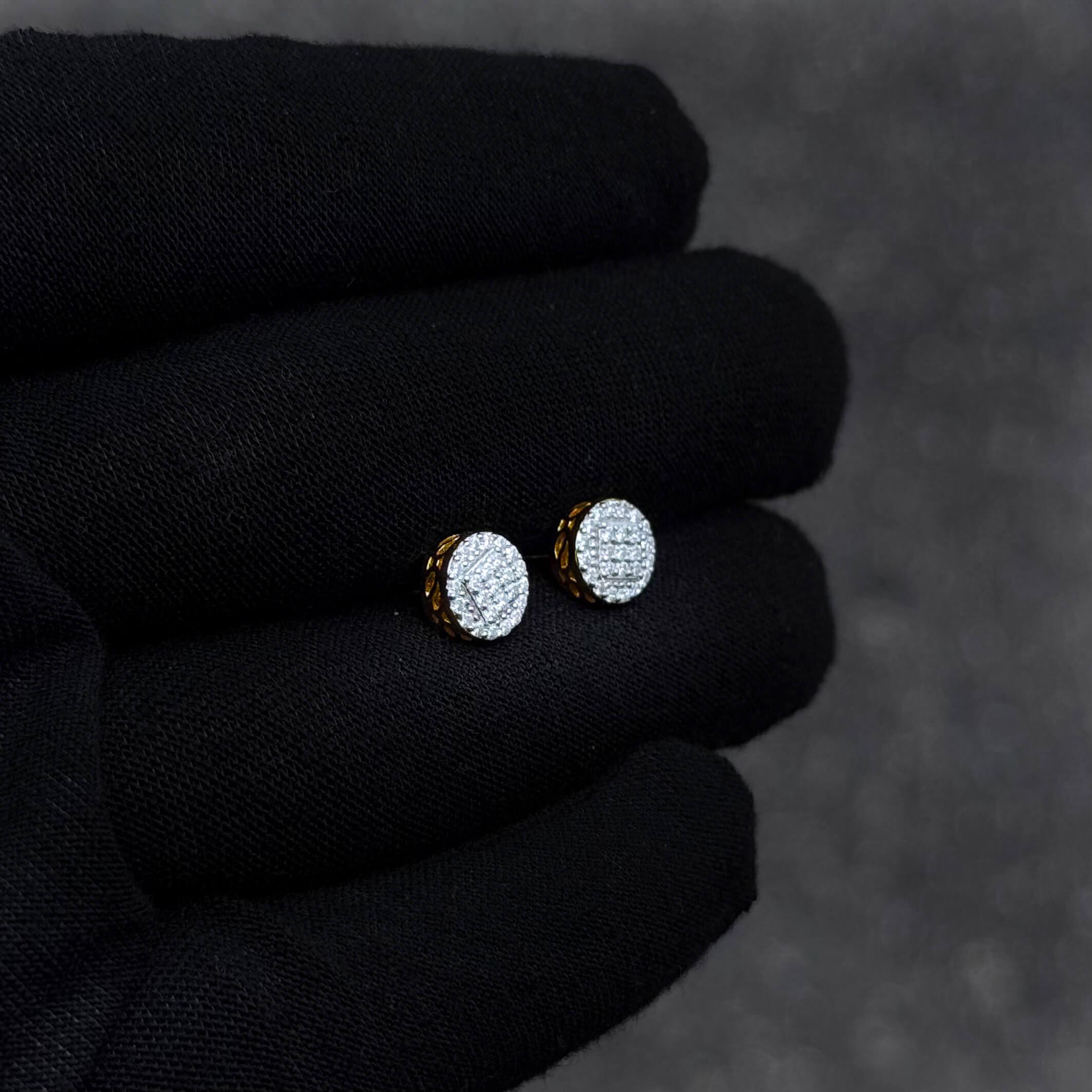 Gold-accent 7mm moissanite cluster diamond stud earrings shown on black glove for close-up detail.